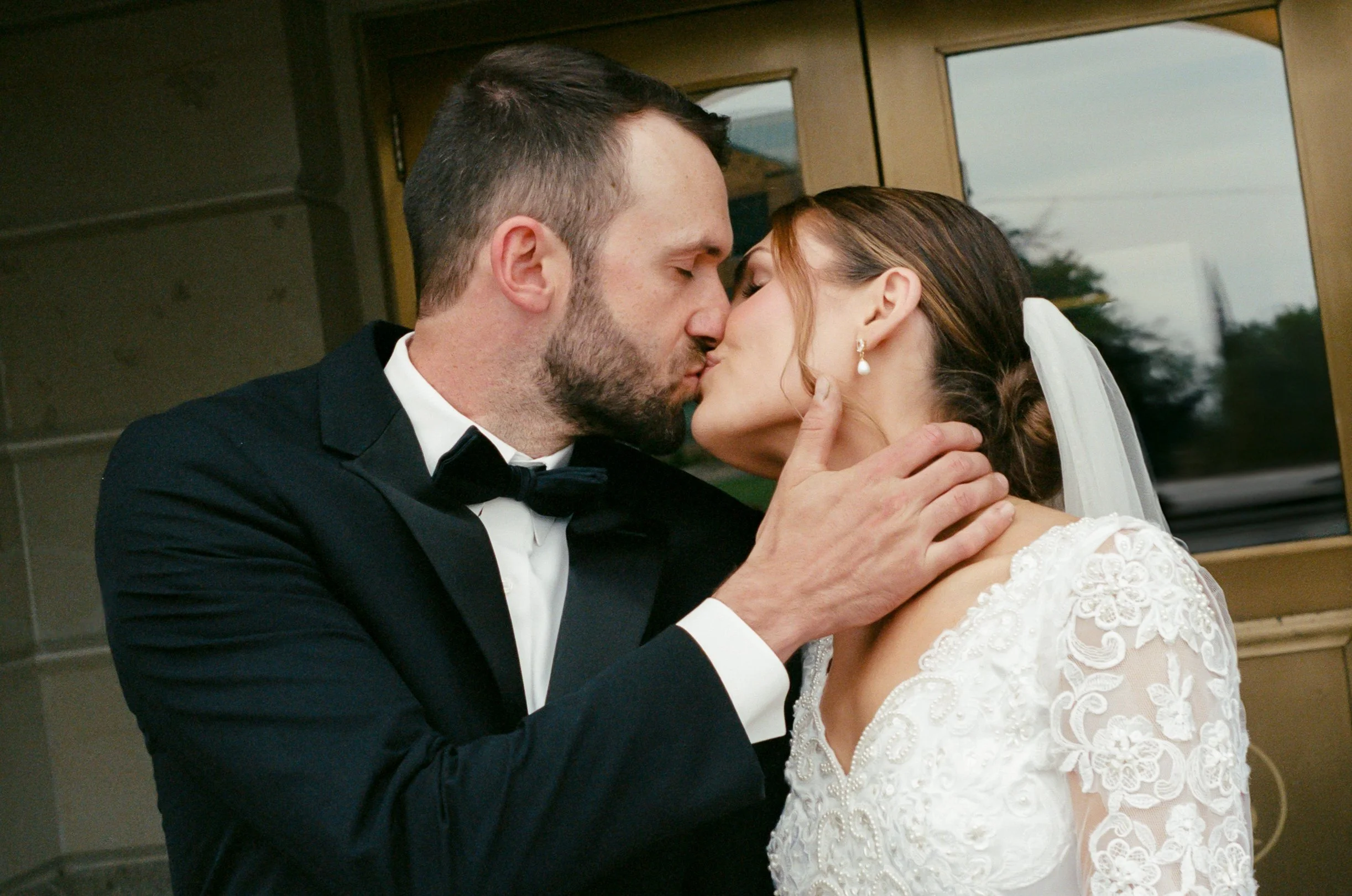 35mm film portrait of newlyweds kissing outside of the Kansas State Capitol.