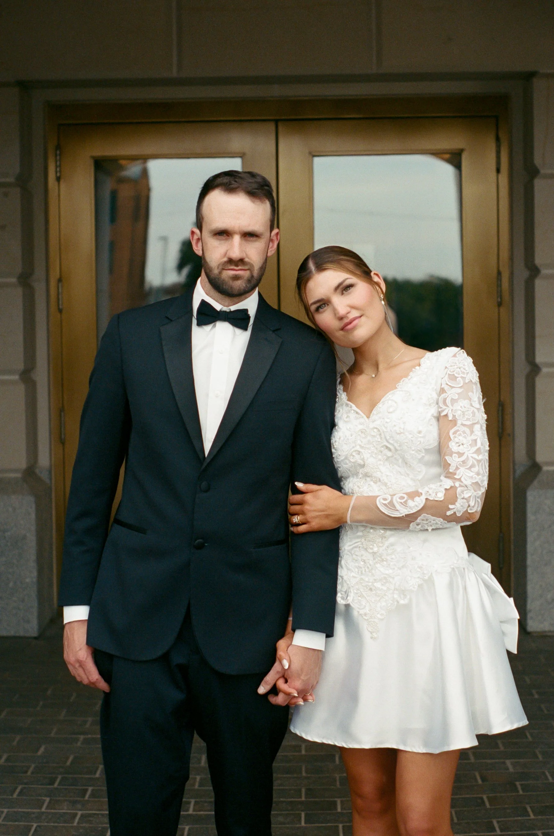 35mm film portrait of newlyweds standing outside of the Kansas State Capitol.