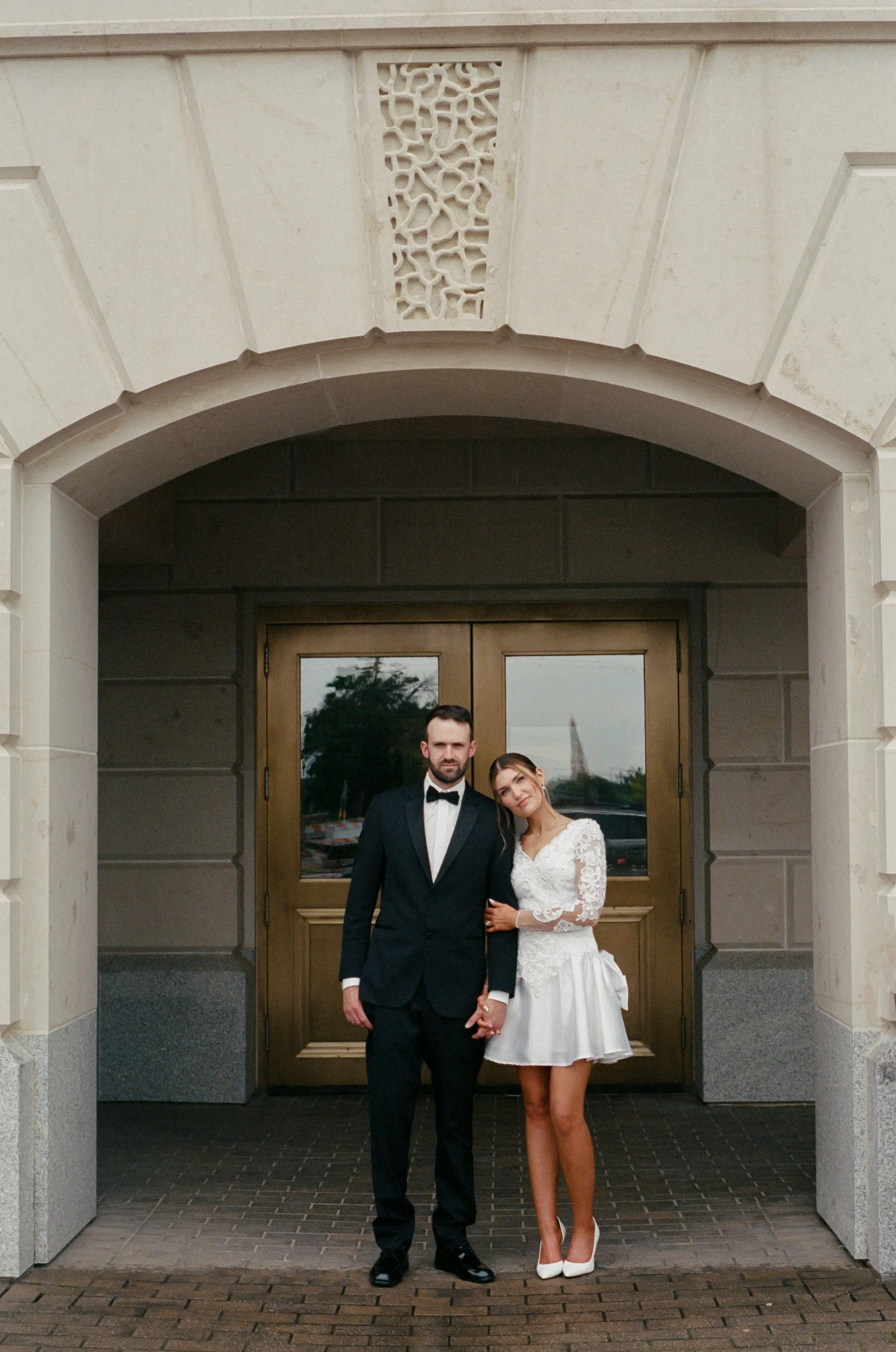 35mm film portrait of newlyweds standing outside of the Kansas State Capitol.