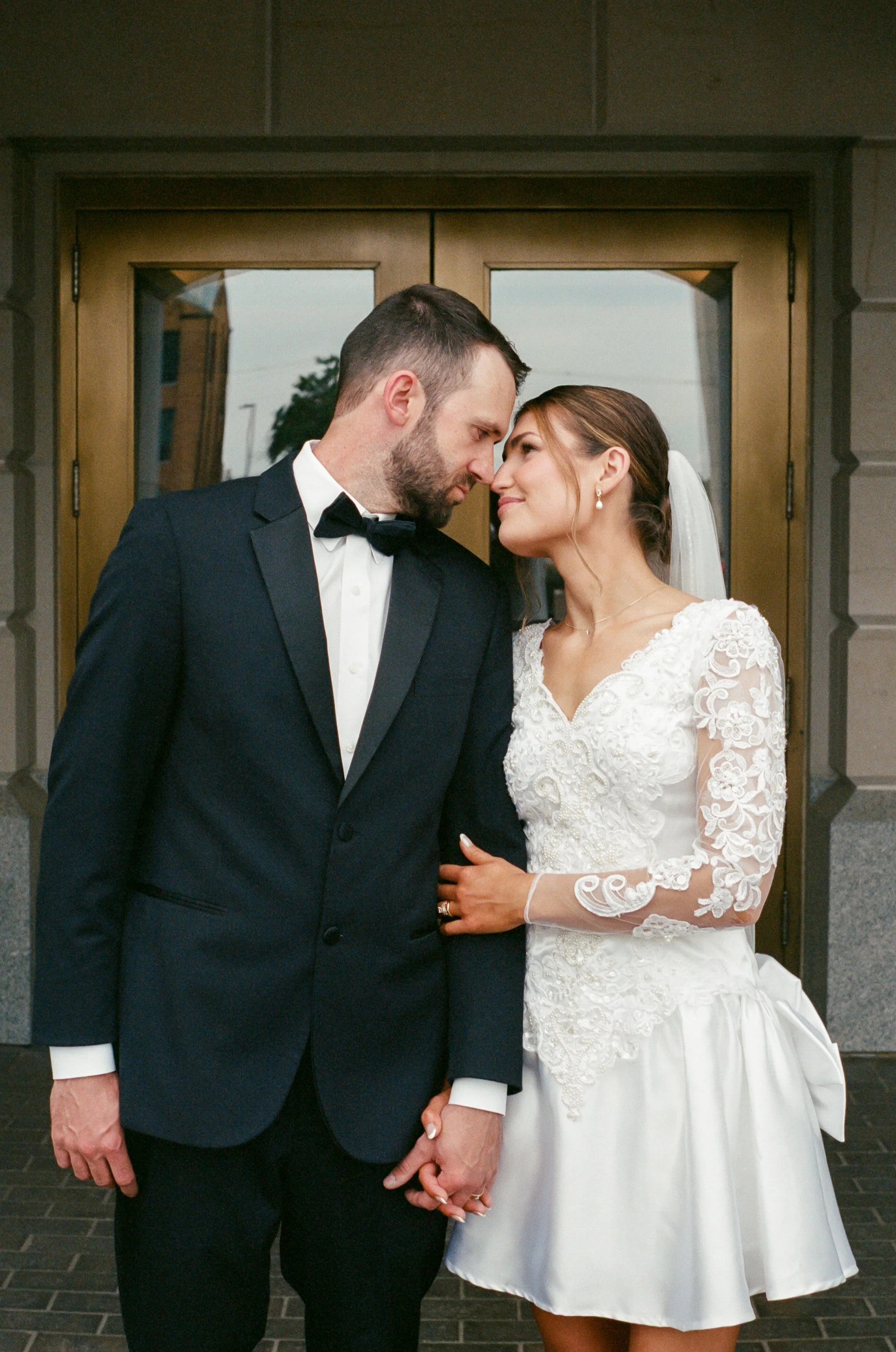 35mm film portrait of newlyweds looking at each other at the Kansas State Capitol.