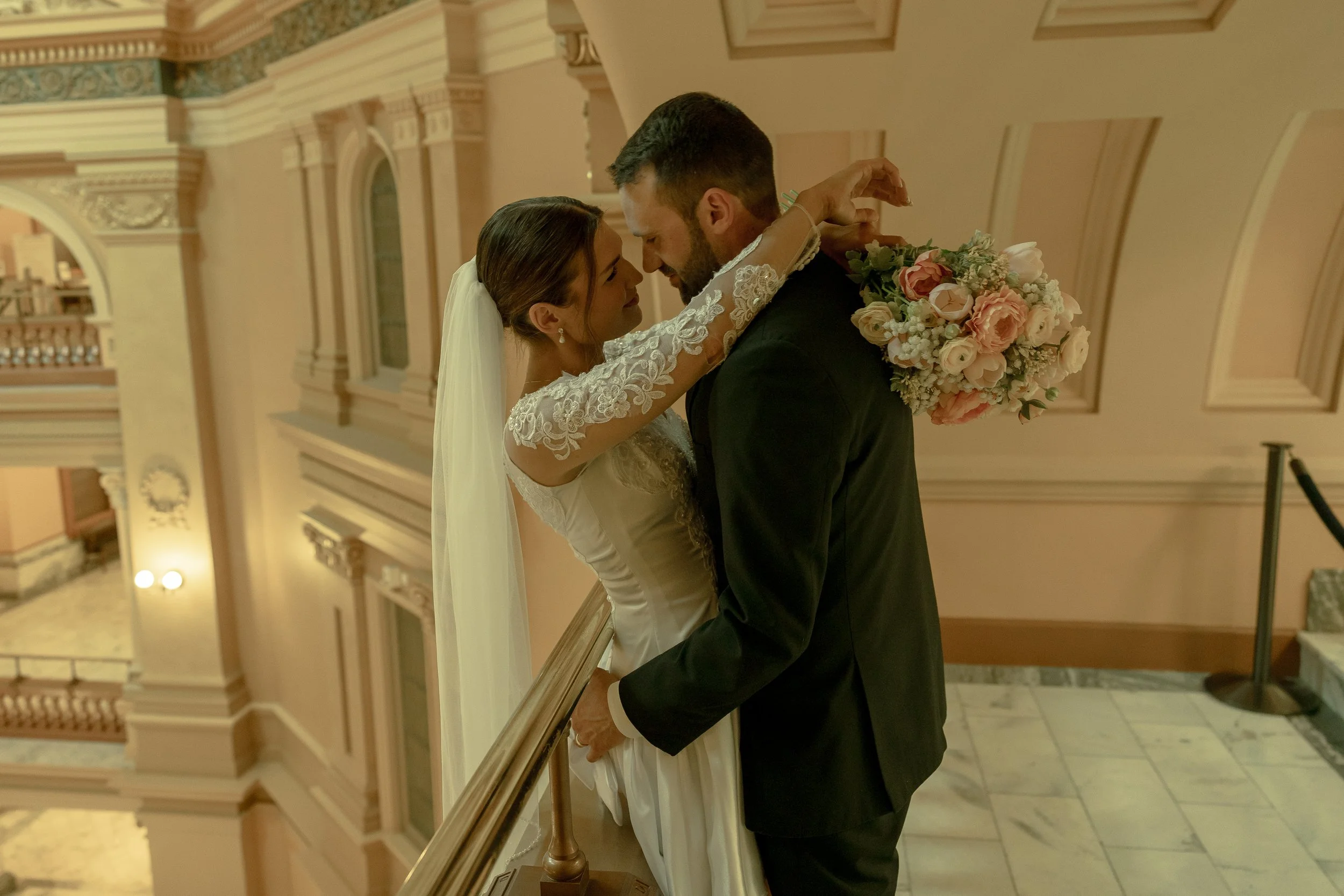 Bride & Groom romantically embracing inside of the Kansas State Capitol Building.