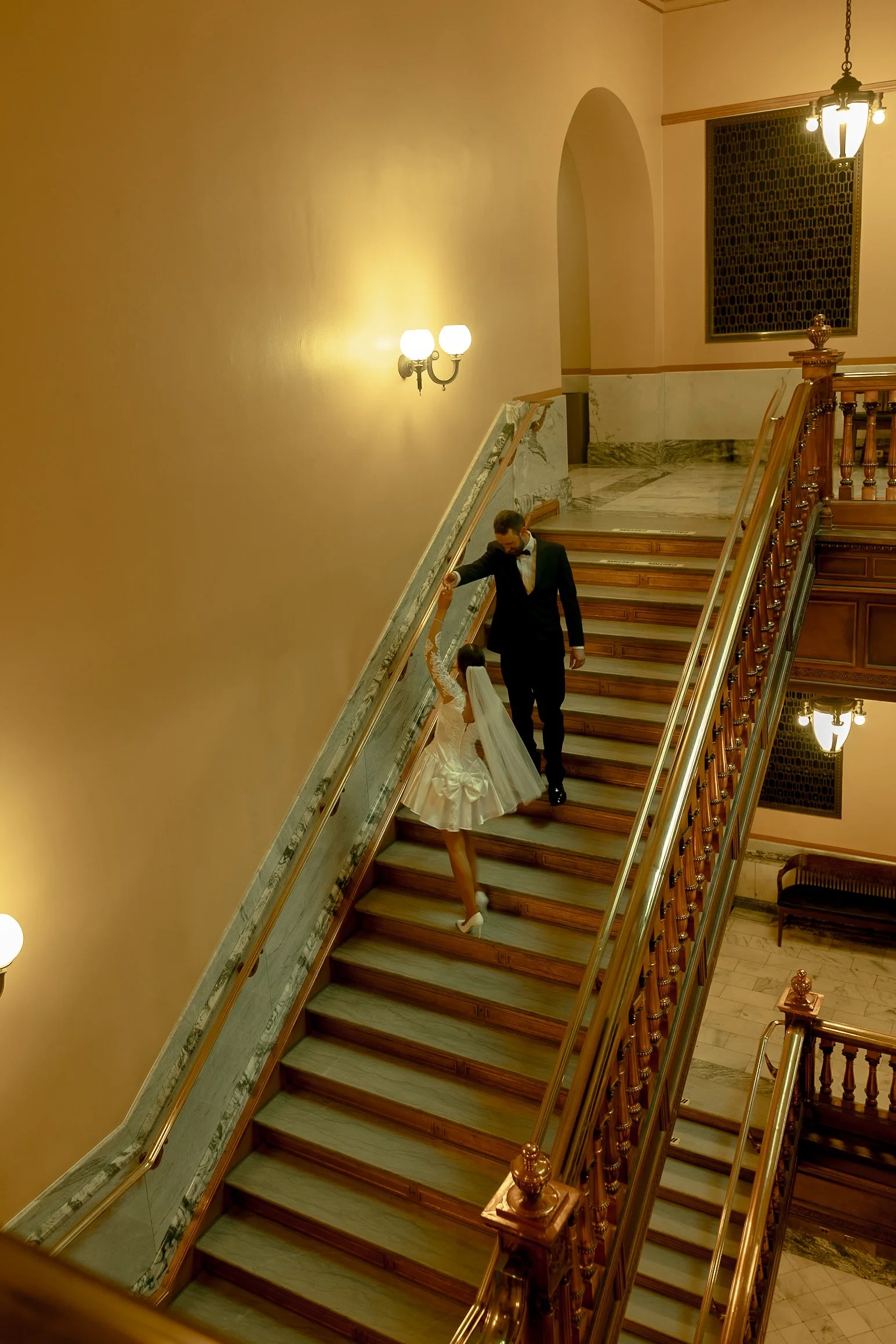 Bride and groom spinning on the grand staircase inside the Topeka State Capitol.