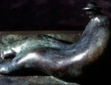 Close-up of a metal sculpture resembling a bird resting on a surface.