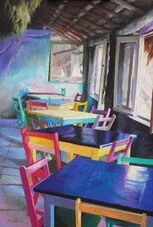 Colorful outdoor patio with multicolored chairs and tables, overlooking a scenic view through open windows.