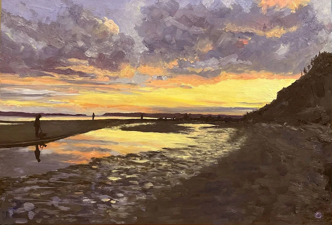 A sunset scene at the beach with a colorful sky, silhouettes of people near the shoreline, and reflections of the sky on the wet sand and water.
