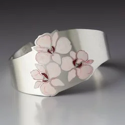 Silver cuff bracelet with white and pink flower design.