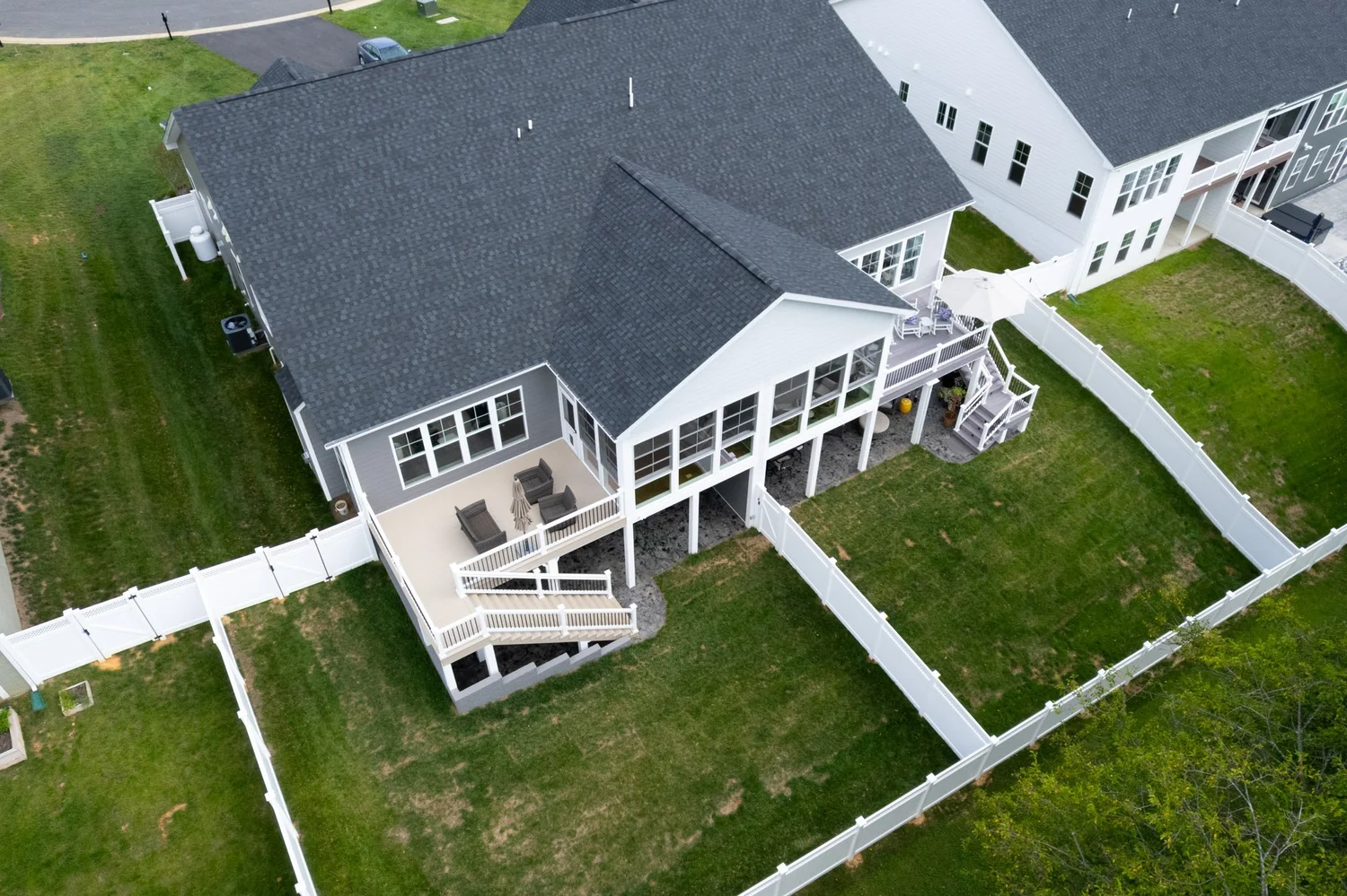 Aerial angle on the home showing the porch addition, deck and fenced yard