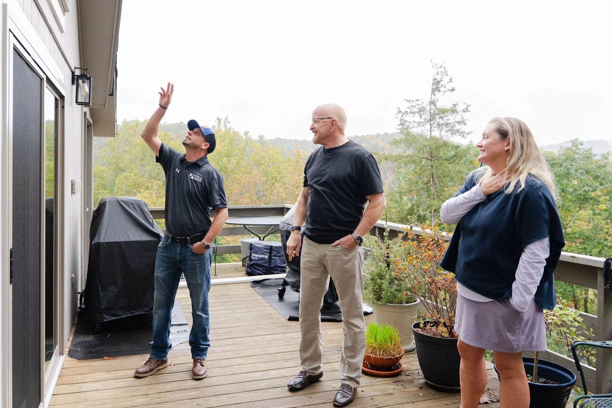 PWD Home installer points up at new windows while talking with homeowners on their deck during a window and door project near Harrisonburg, VA