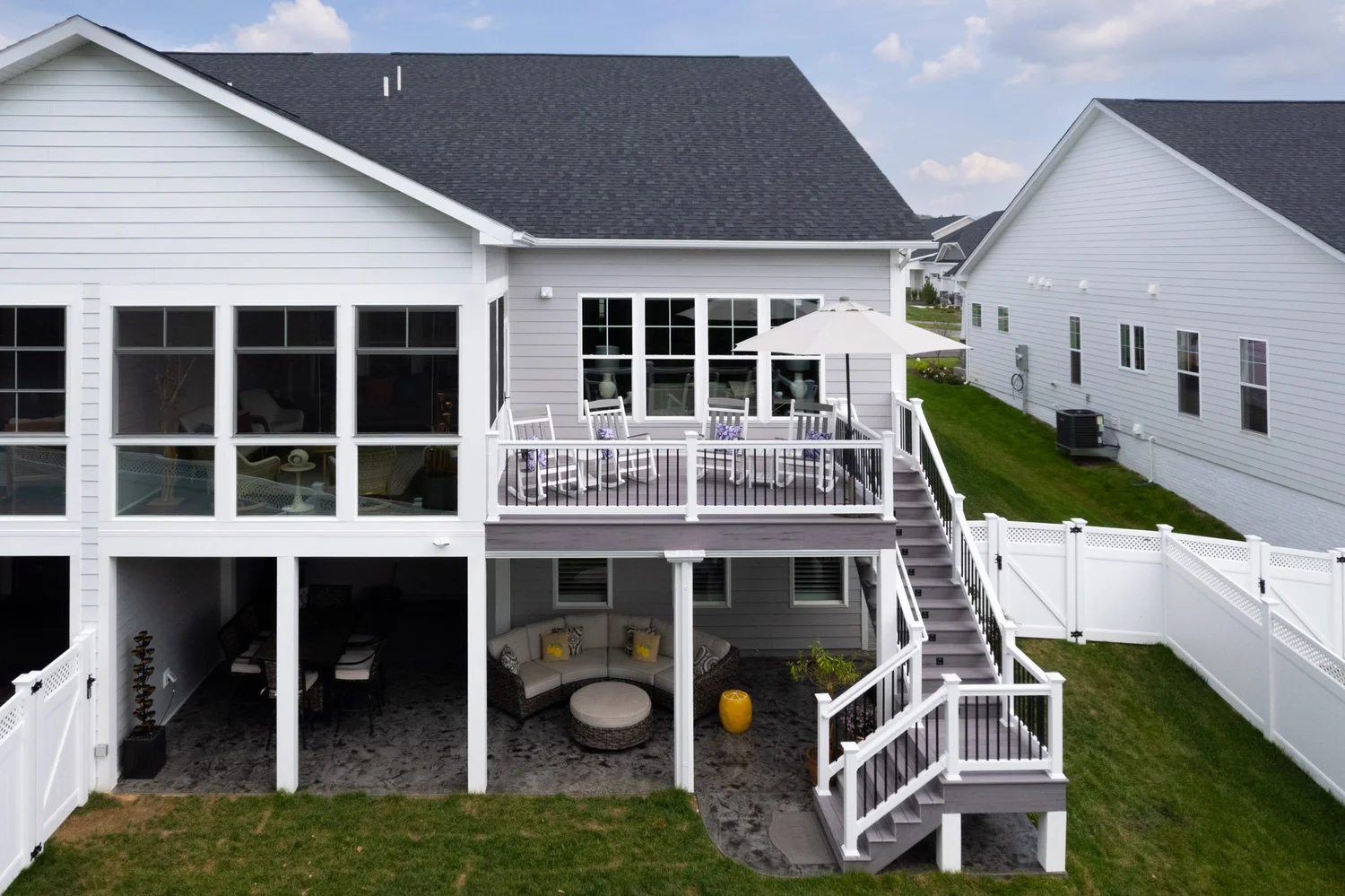 Aerial rear view of both units, each with an enclosed porch, deck and furnished patio below