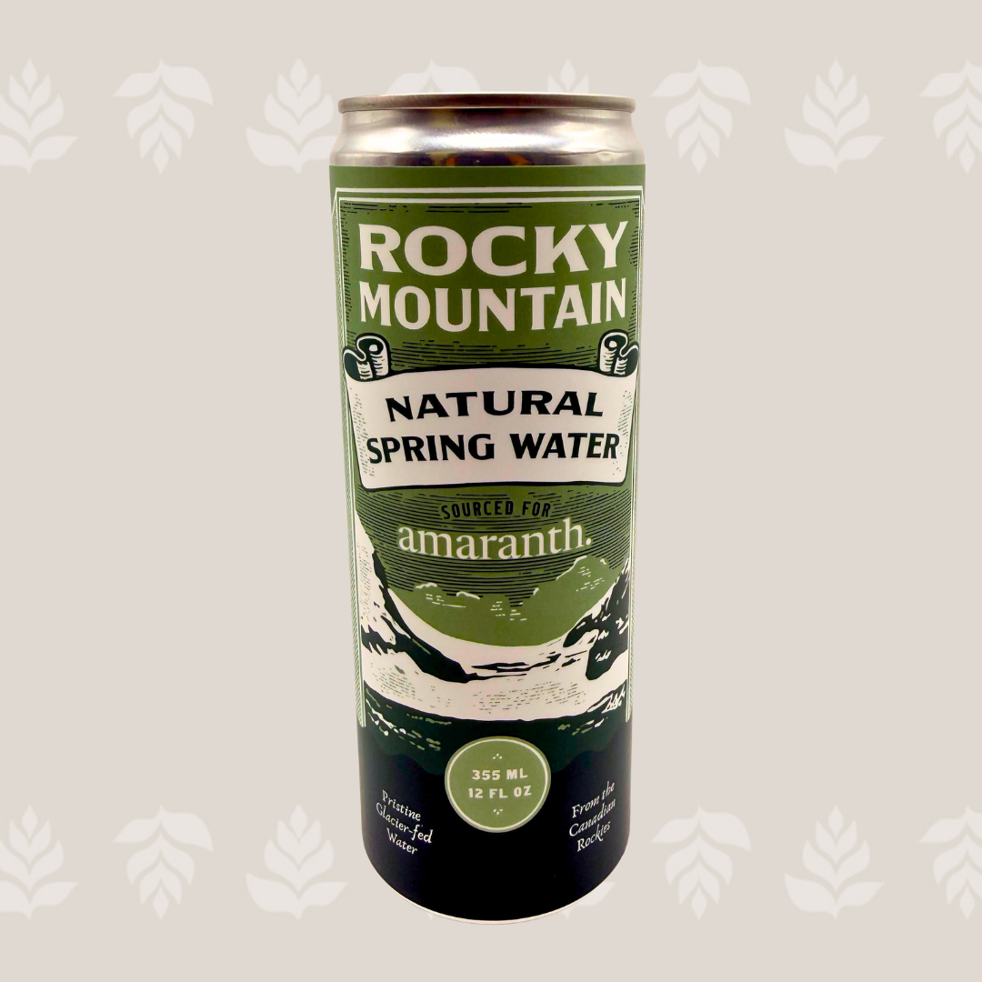 A can of Rocky Mountain Natural Spring Water with mountain and river illustrations on the label.