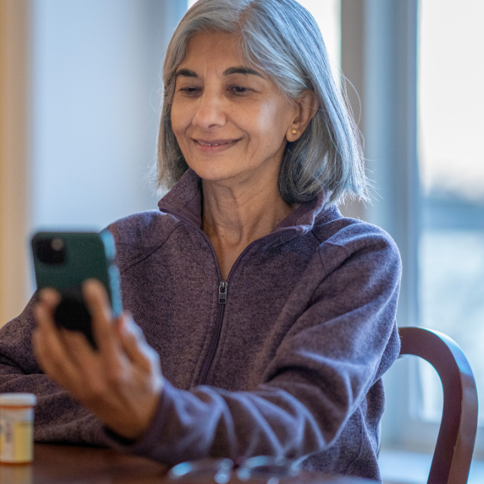 Older woman looking at laptop and smiling