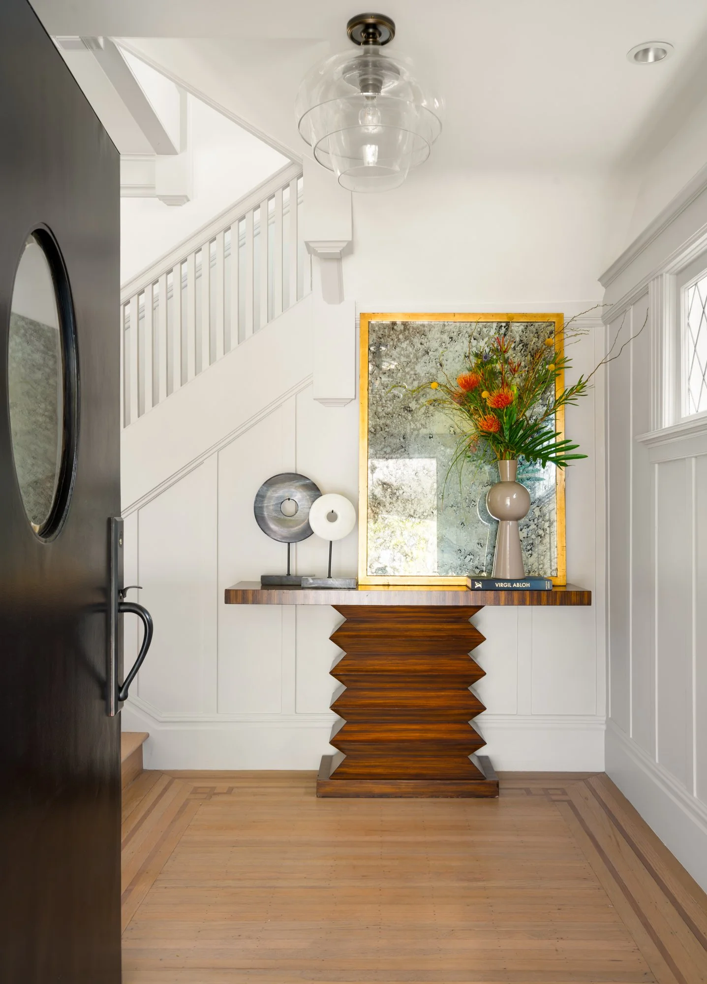 Modern entryway with wooden console and flower arrangement