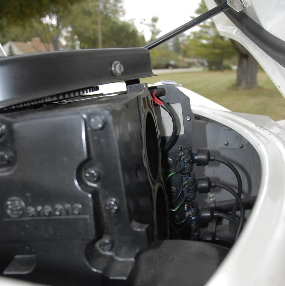 Close-up view of an engine inside a small vehicle with some wires and mechanical parts visible.