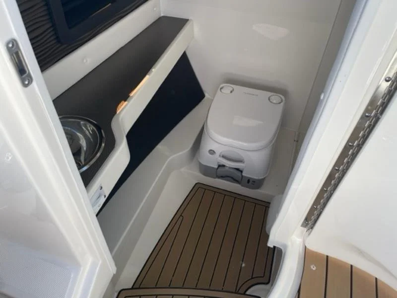 Compact boat washroom head area with a modern toilet, small sink on a Sea Ray 280 SLX.