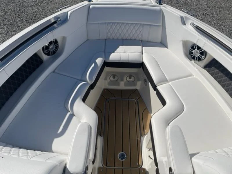 View of the bow of a yacht with white cushioned seating arranged in a U-shape, speakers on the sides. Sea Ray 280 SLX.