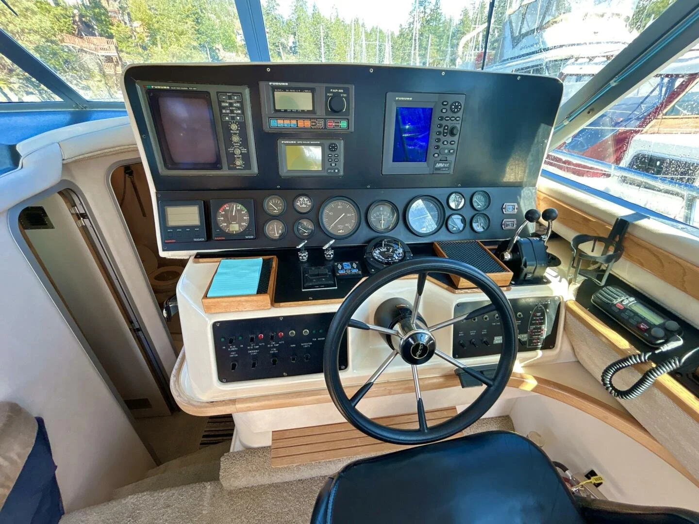 Boat cockpit dashboard with electronic navigation instruments, gauges, and control levers.