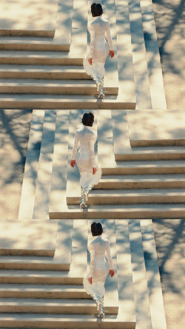 Repeated image of a woman in a white dress walking up steps, with mirrored reflections creating a triptych effect.