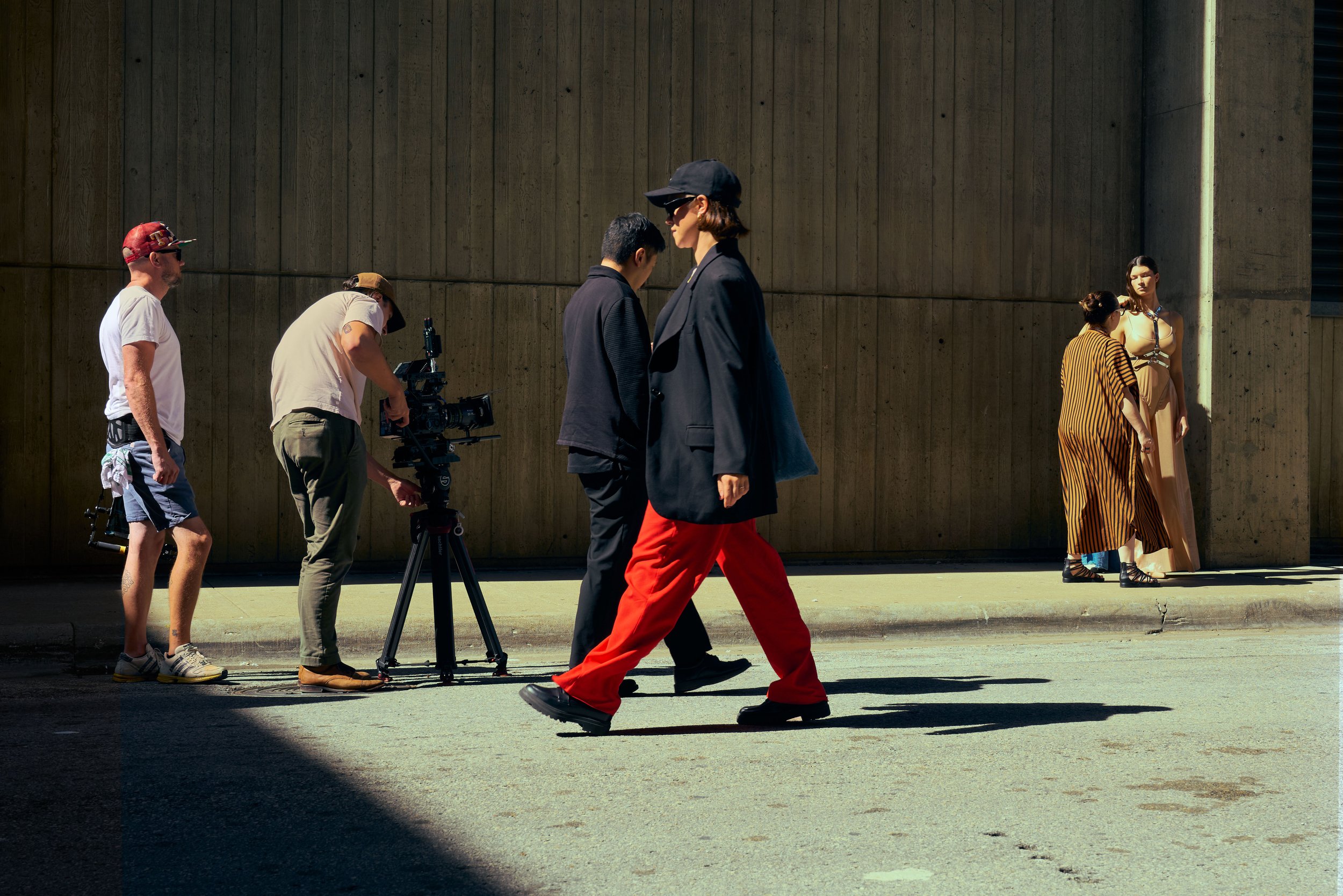 Fashion photoshoot scene with a camera crew and a model in urban setting