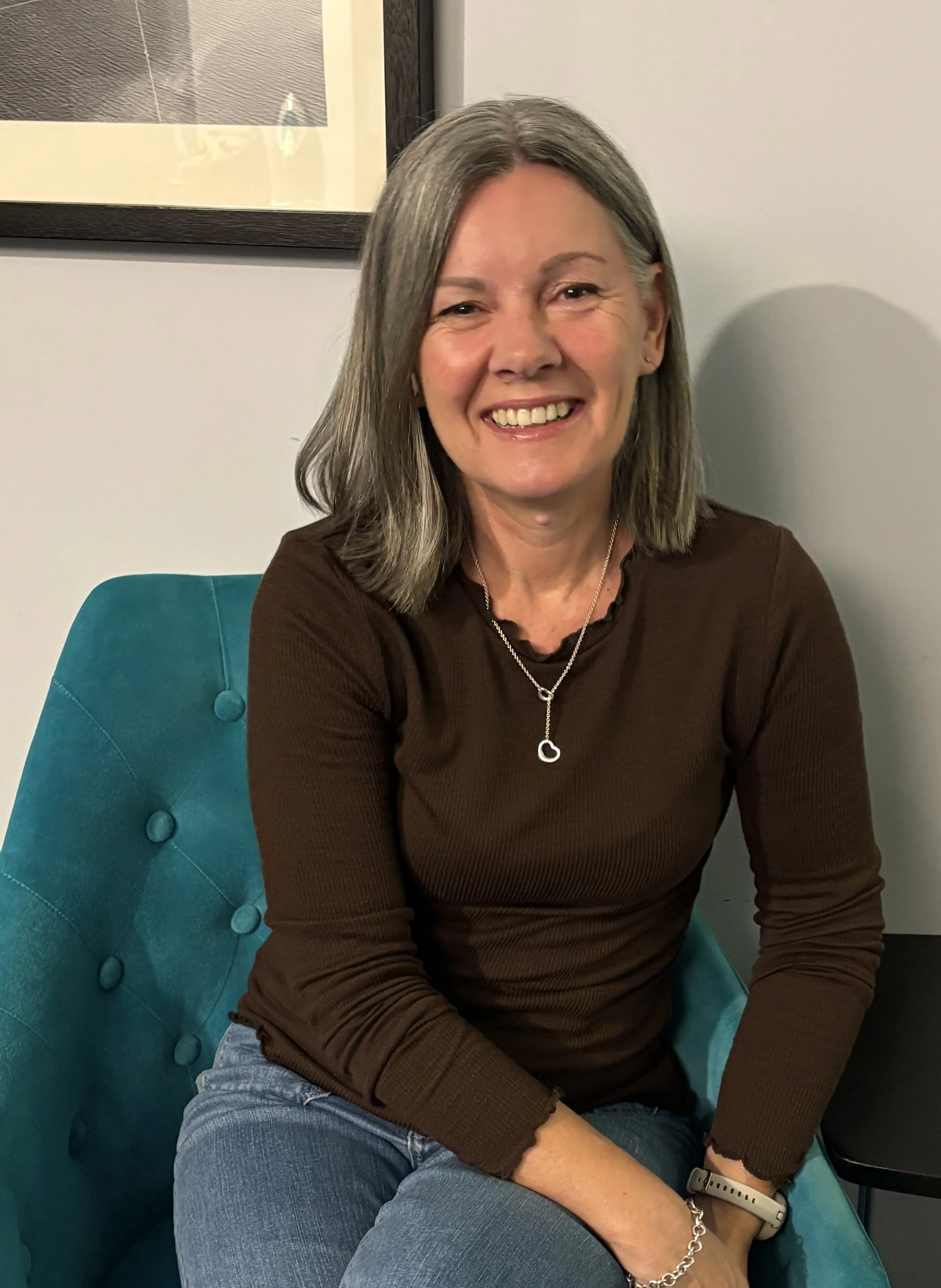 CathyHockey Executive Coach is sitting and smiling at the camera