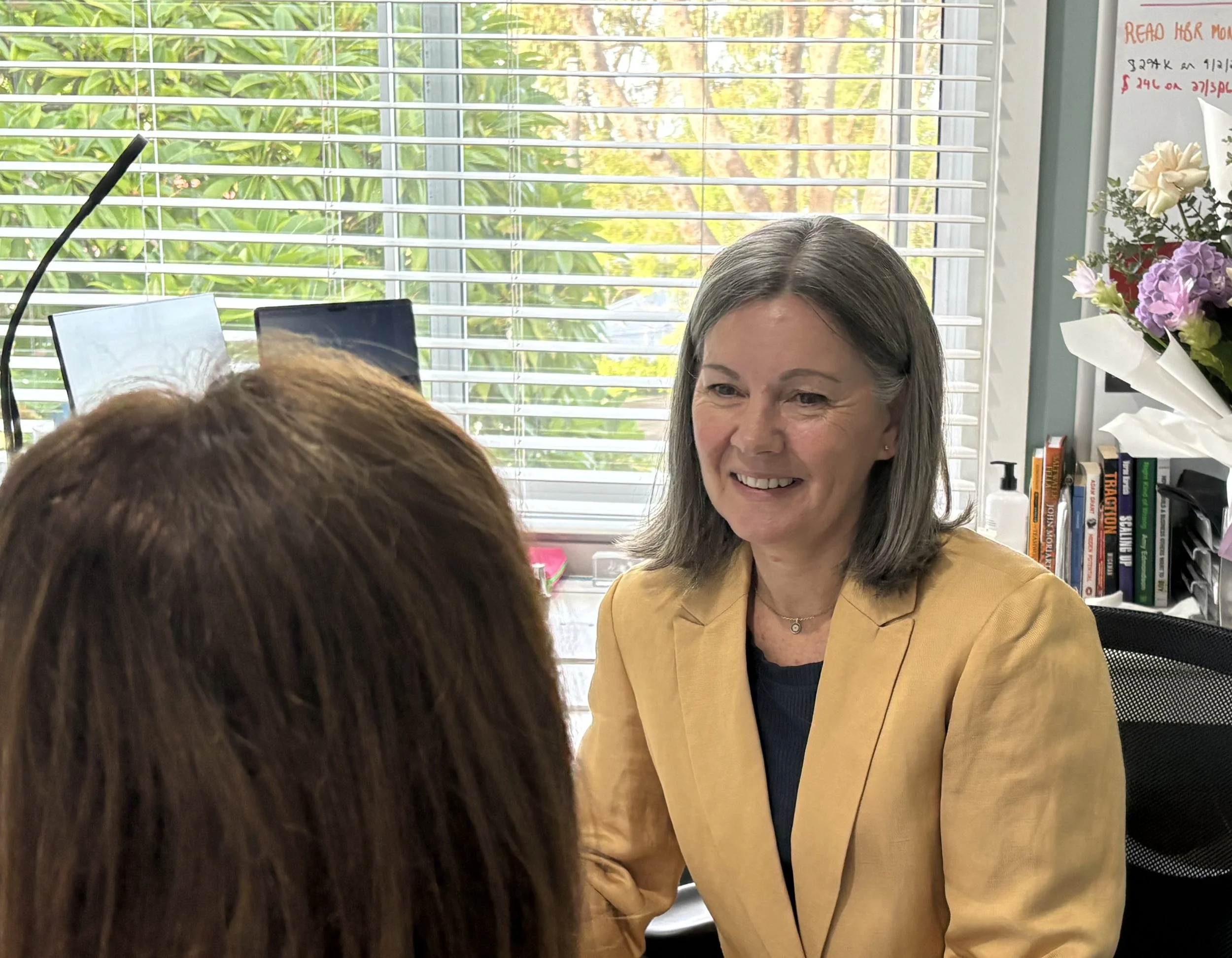 Cathy organisational coaching a client, sitting together and smiling