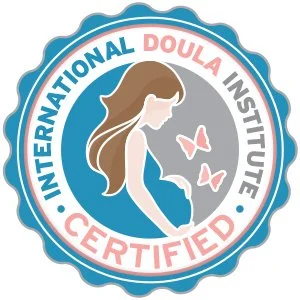 A logo for the International Doula Institute featuring a pregnant woman with long brown hair, surrounded by butterflies and the organization's name in a circular design.