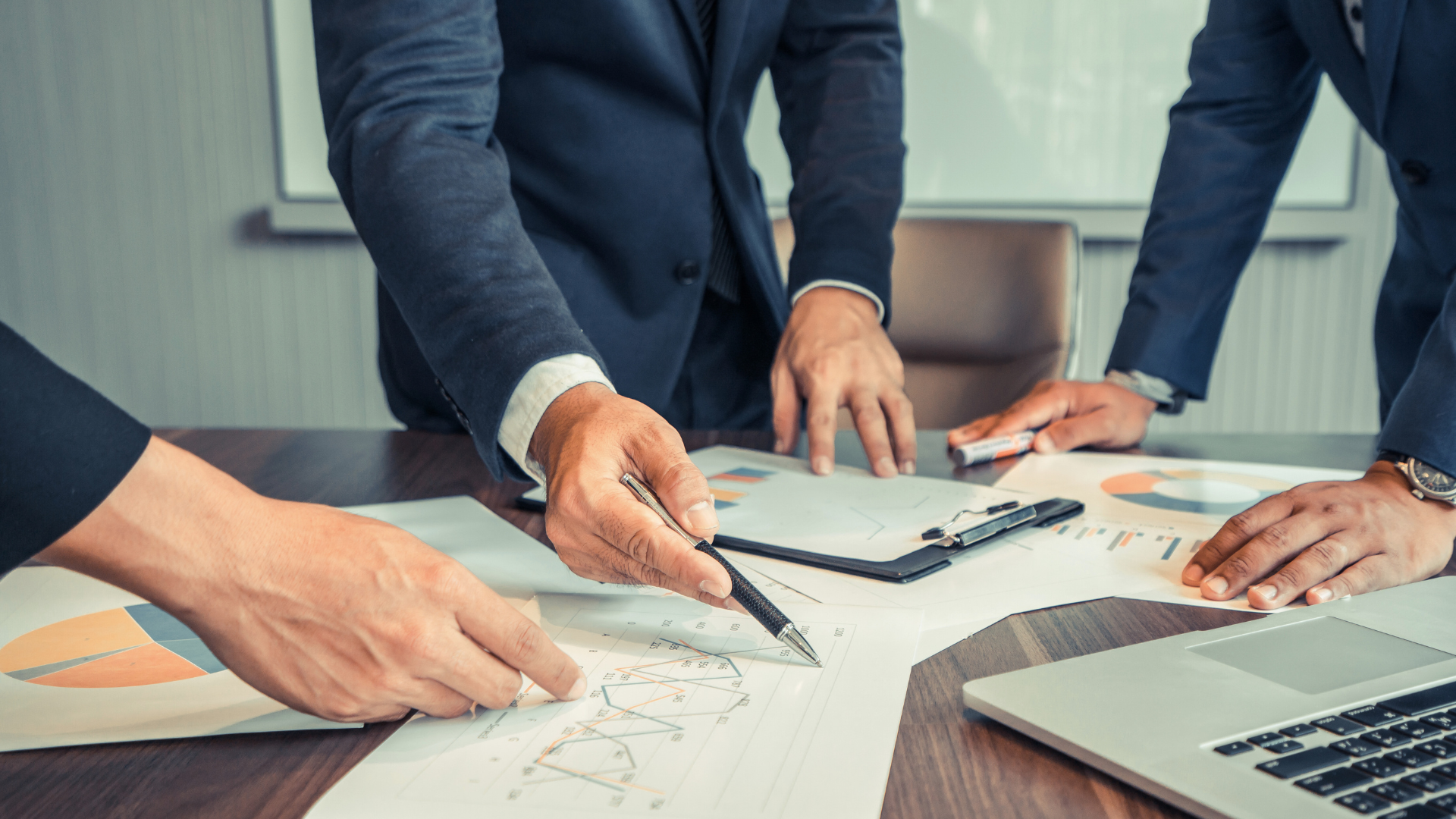 Business professionals discussing financial charts and graphs at a meeting table