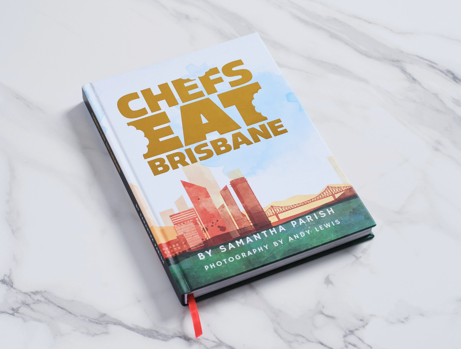 A hardcover book titled "Chef's Guide to Brisbane" by Samantha Parish with photography by Andy Lewis, placed on a white marble surface.
