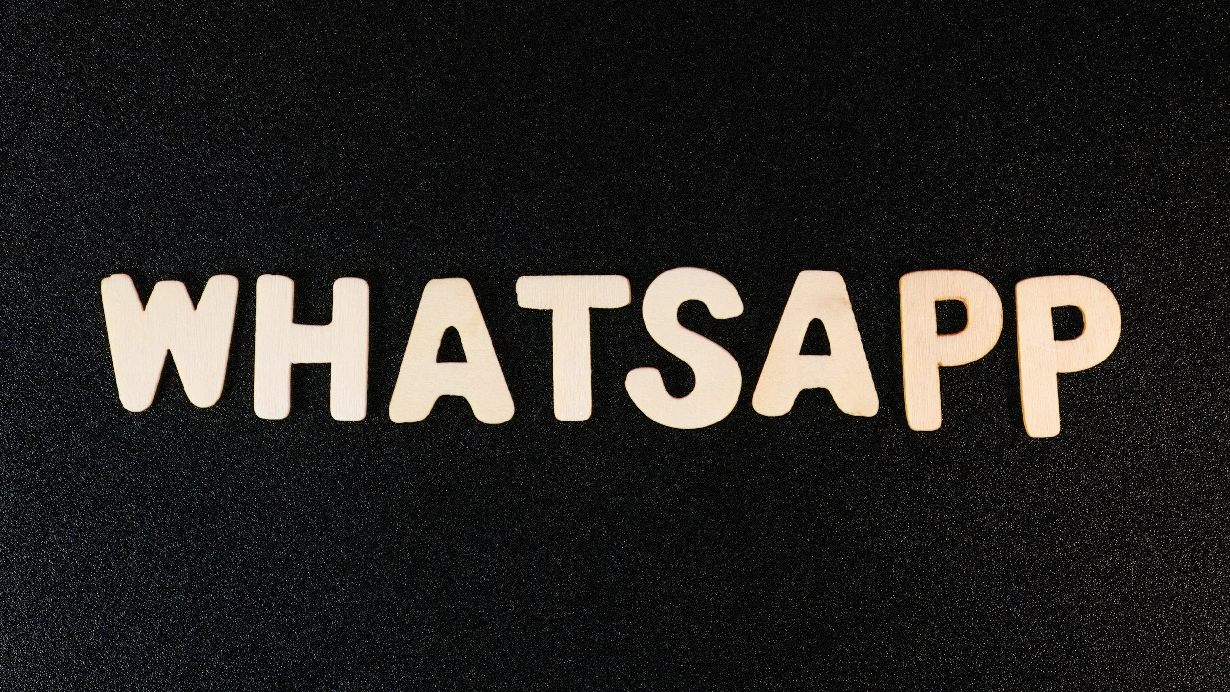 Der Schriftzug 'WHATSAPP' in weißen Buchstaben auf schwarzem Hintergrund. Direktkontakt per WhatsApp-Chat. Unkomplizierte Online-Kommunikation. Unkomplizierte Online-Kommunikation bei Onterior - Dein Online Interior Design Studio.