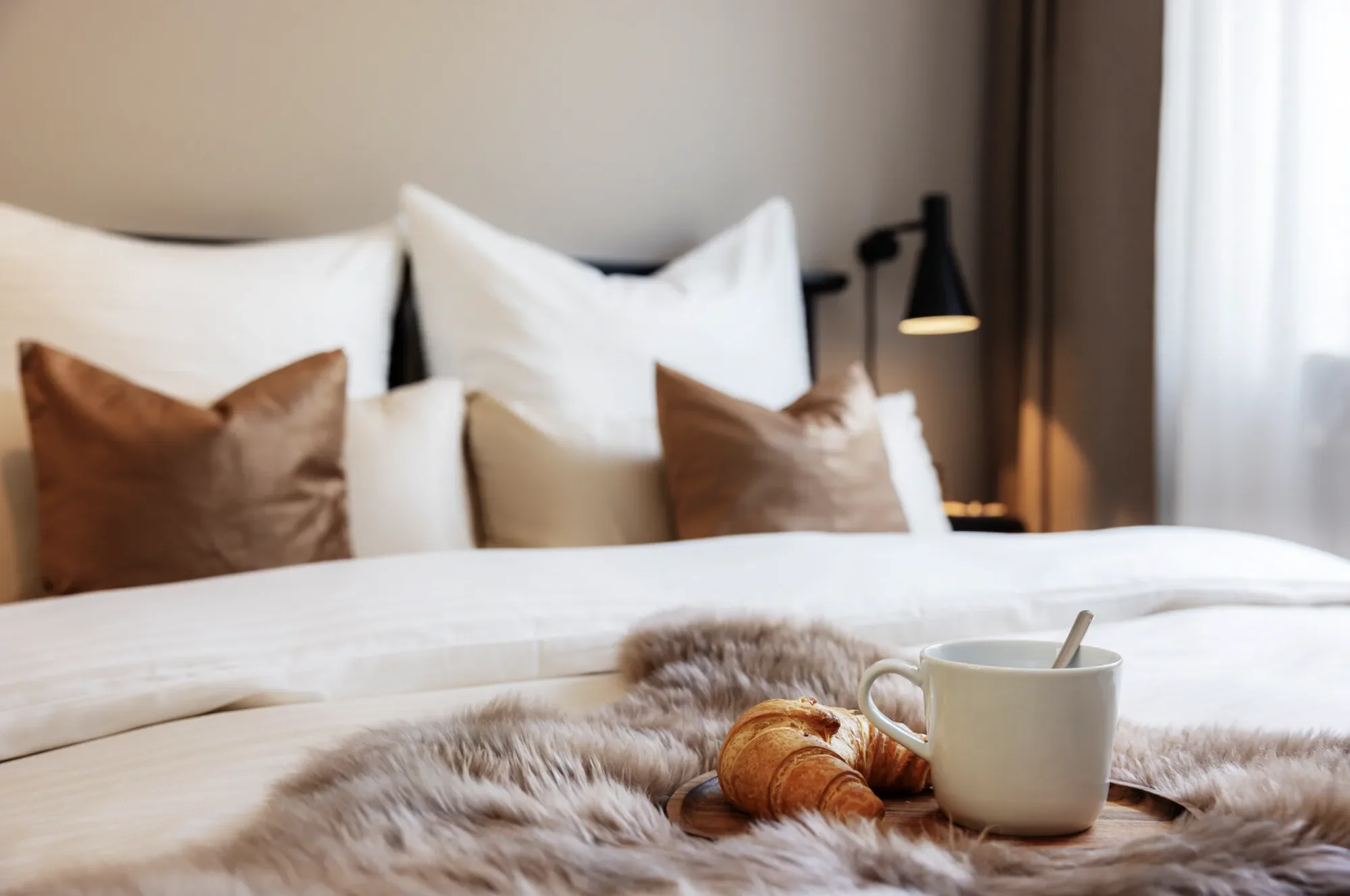Ein gemütliches Bett, dekoriert und professionell inszeniert für die moblierte Vermietung und AirBnB.