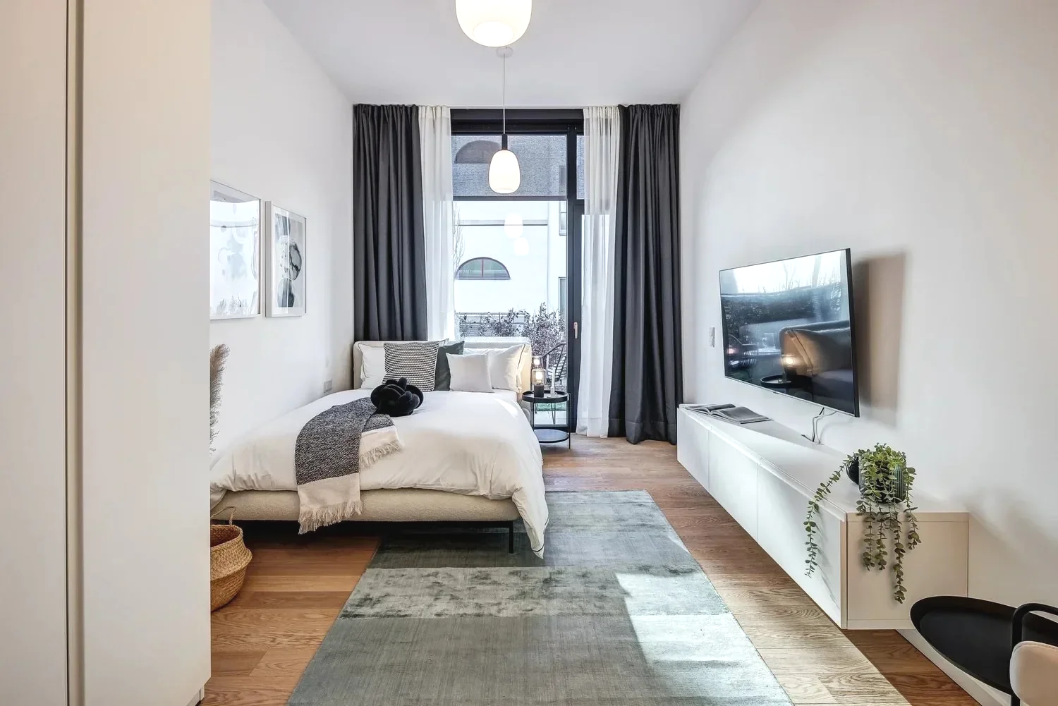 Modernes Schlafzimmer mit Doppelbett, Holzboden, natürliche Beleuchtung. modernes Zimmer als 1-Zimmer Wohnung gestalten mit Onterior. Apartment einrichten mit Onterior. Einirichtungsplanung und Beratung Online, deutschlandweit.