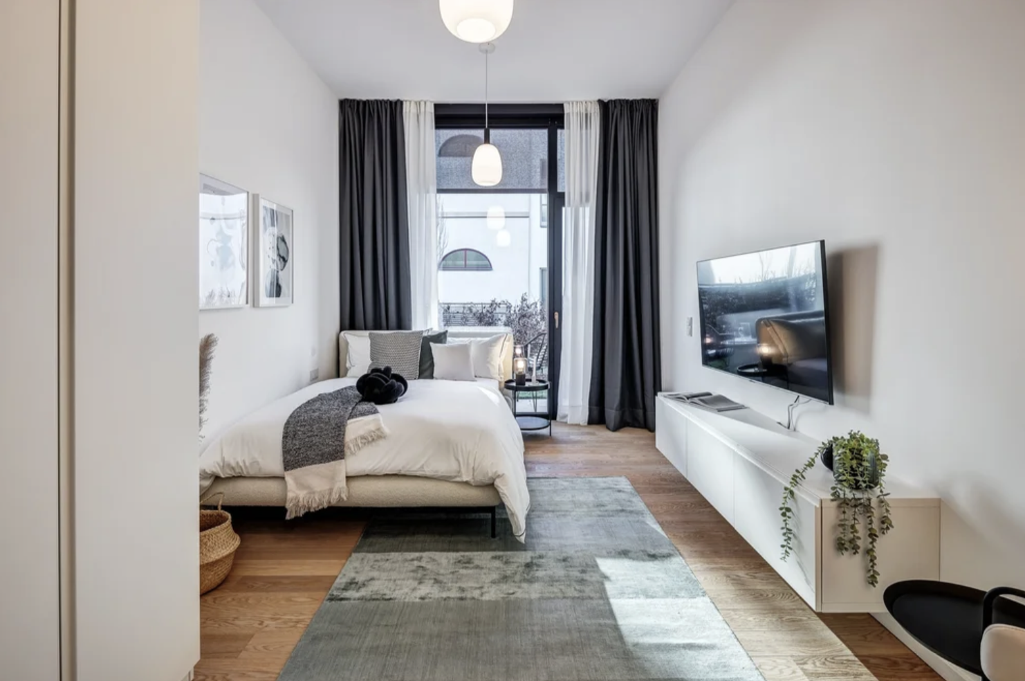 Modernes Schlafzimmer mit Doppelbett, Holzboden, natürliche Beleuchtung. modernes Zimmer als 1-Zimmer Wohnung gestalten mit Onterior. Apartment einrichten mit Onterior. Einirichtungsplanung und Beratung Online, deutschlandweit.