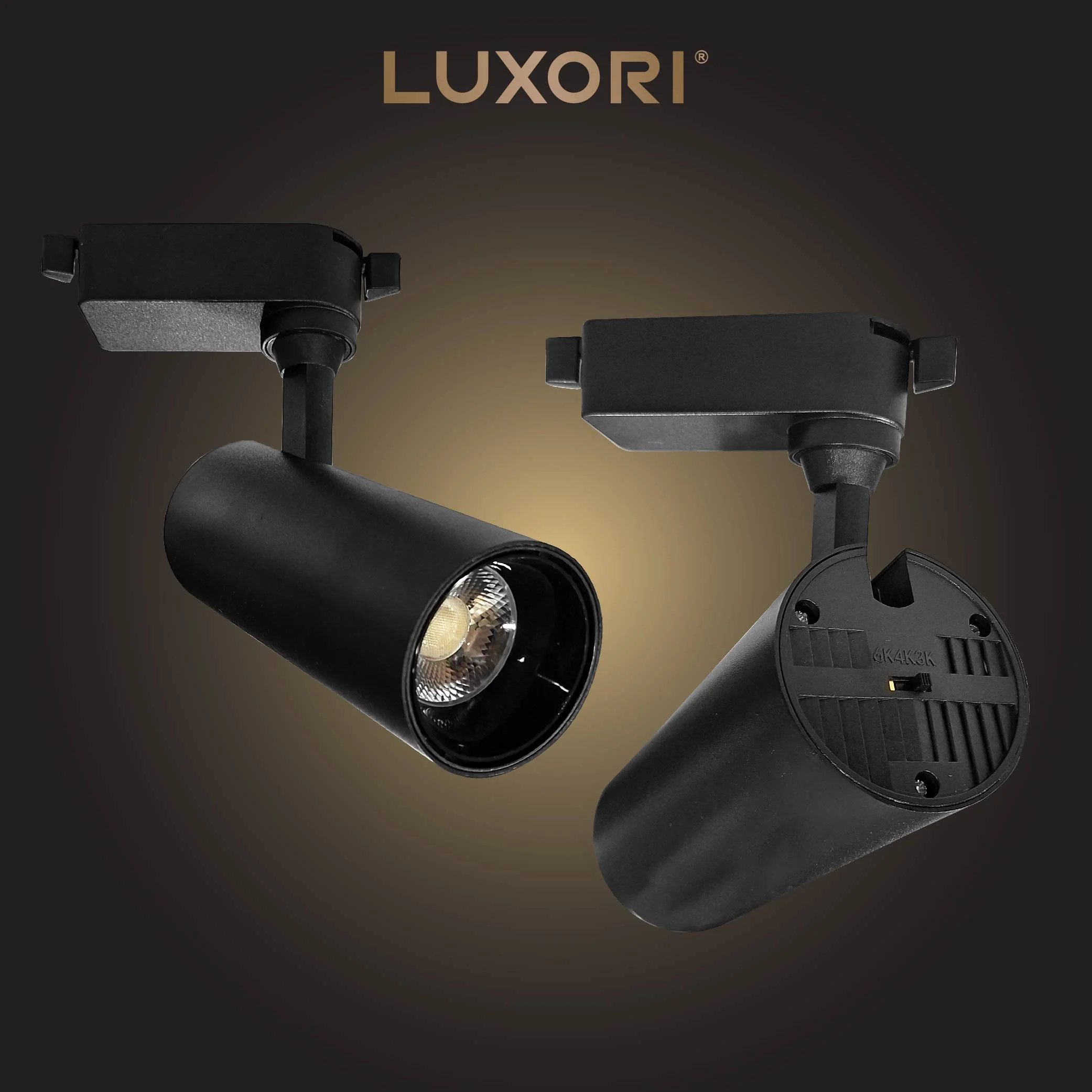 Two black track lighting fixtures, one with a visible light bulb, on a black background with the word 'LUXORI' in gold at the top
