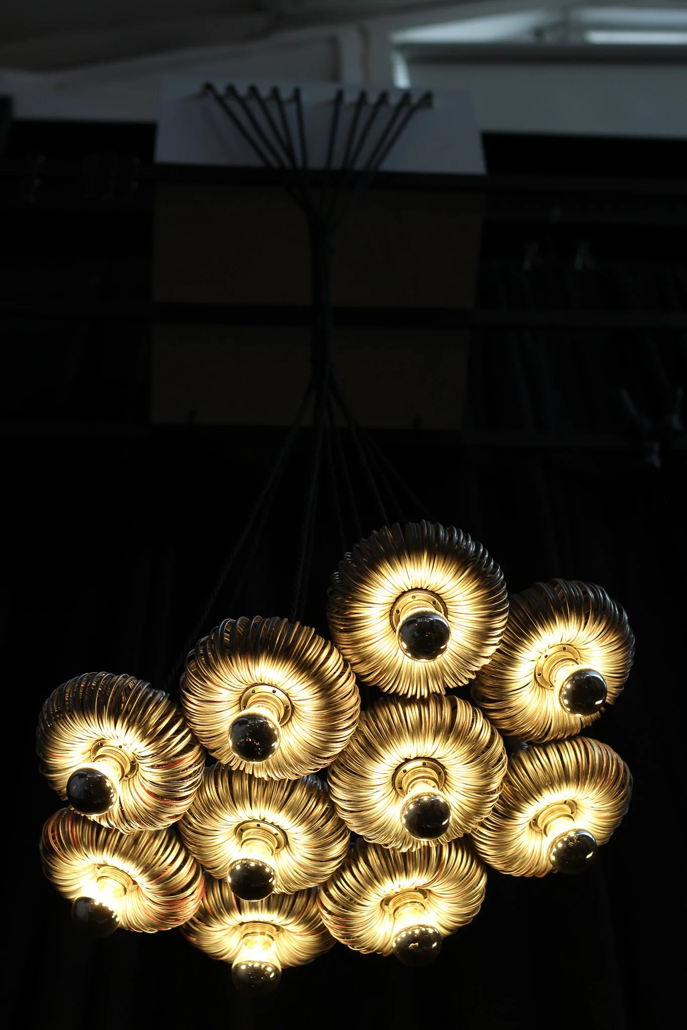 Close-up of a modern chandelier with multiple glowing circular light fixtures arranged in a cluster.