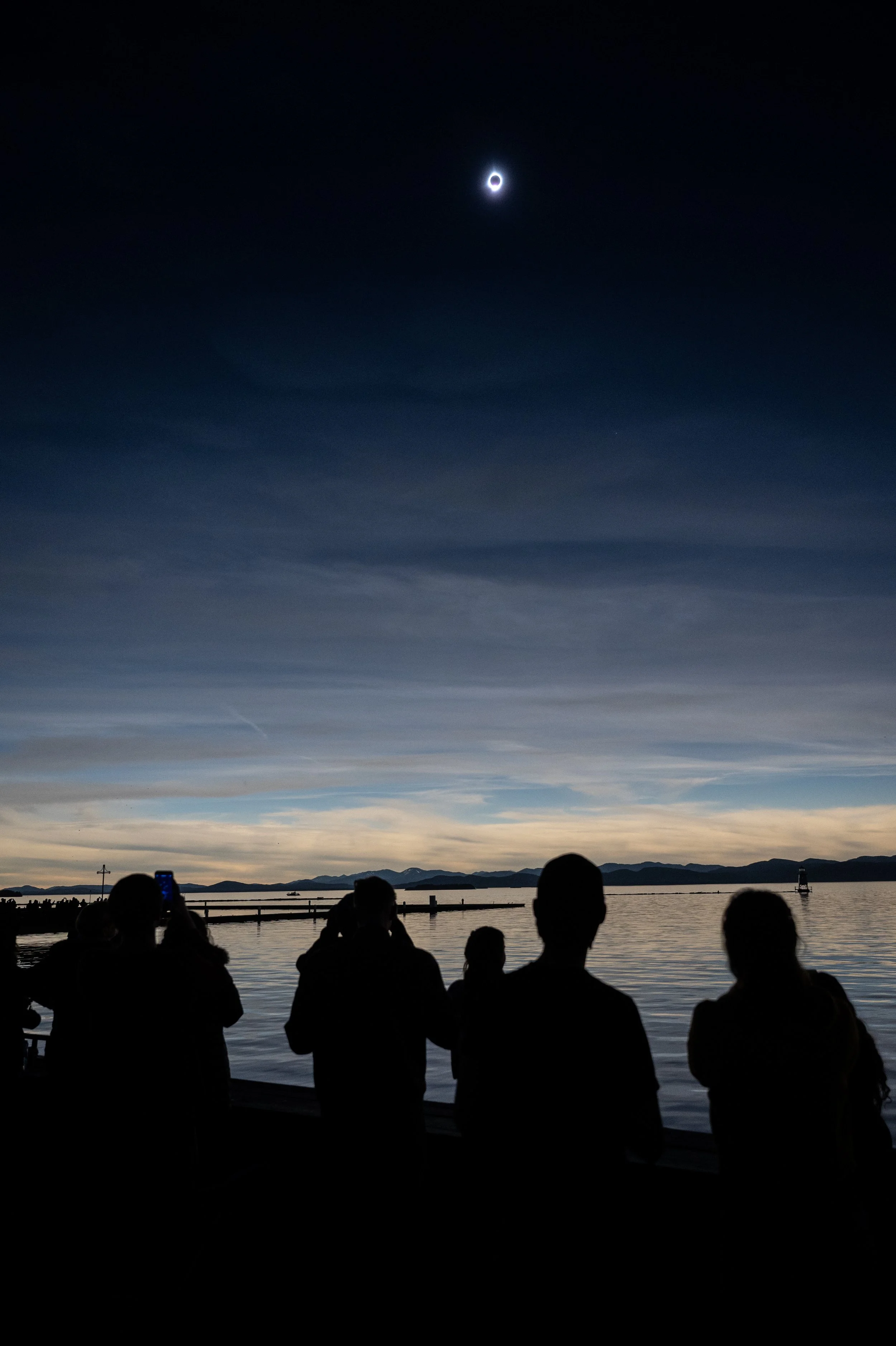 Spectators take in totality over Lake Champlain on April 8, 2024, in Burlington, Vermont. As the moon crossed in front of the sun, the mid-day light turned to dusky sunset, and the crowd erupted in whoops and cheers.