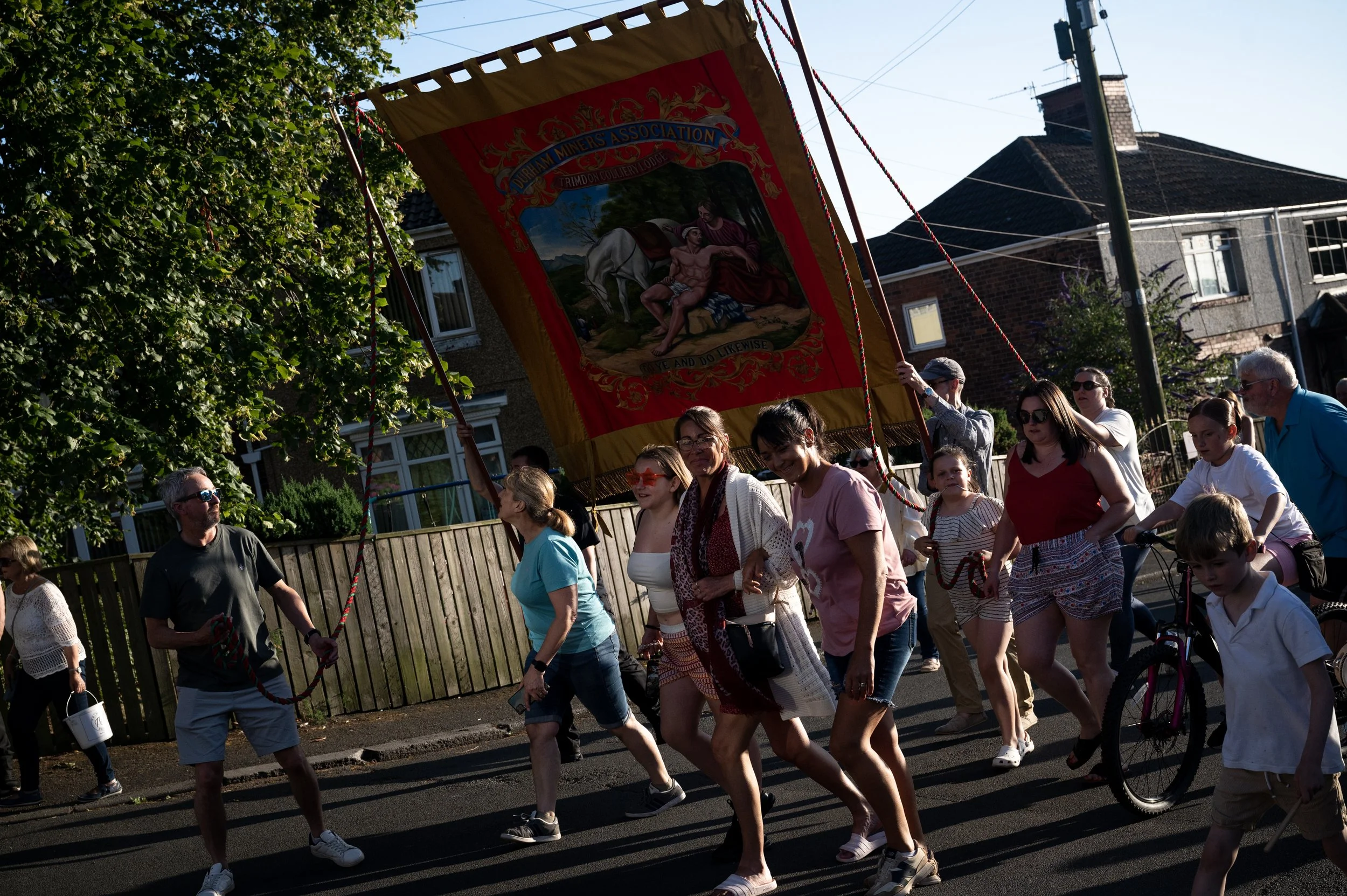 Local families parade the Trimdon miners’ banner through the streets on July 11, 2025, in Trimdon, England. In small mining communities across this area, such as Trimdon, on the evening before the Durham Miners Gala, people parade the local banner th