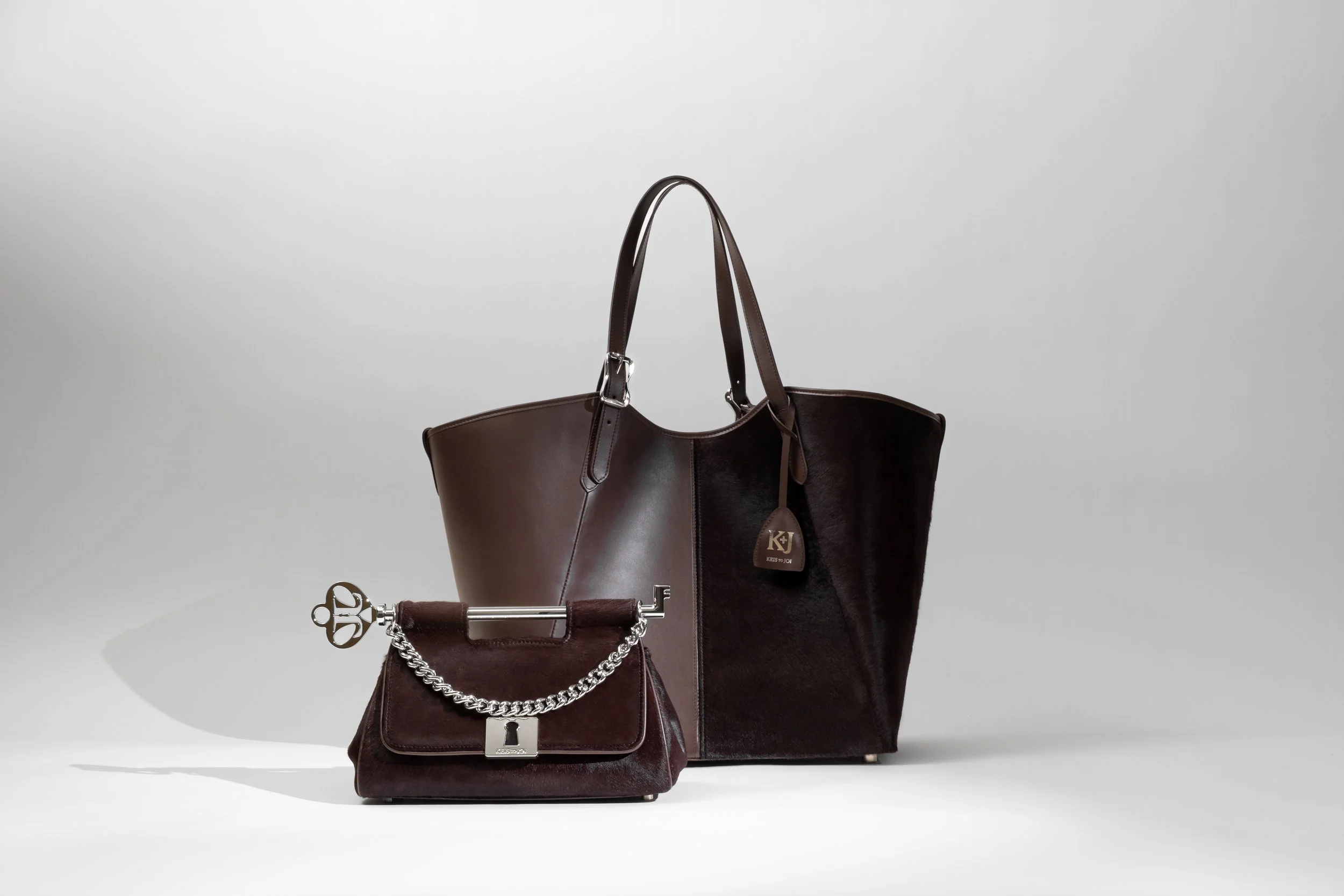 Two brown handbags, a large tote and a small purse, displayed on a plain white background.
