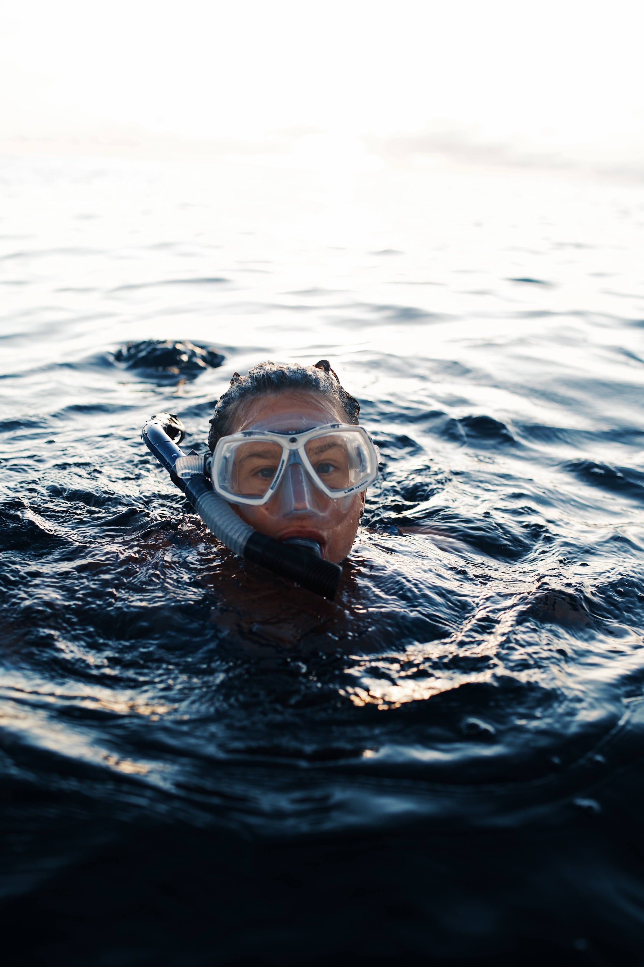 A person with a snorkel and mask swimming in the ocean.