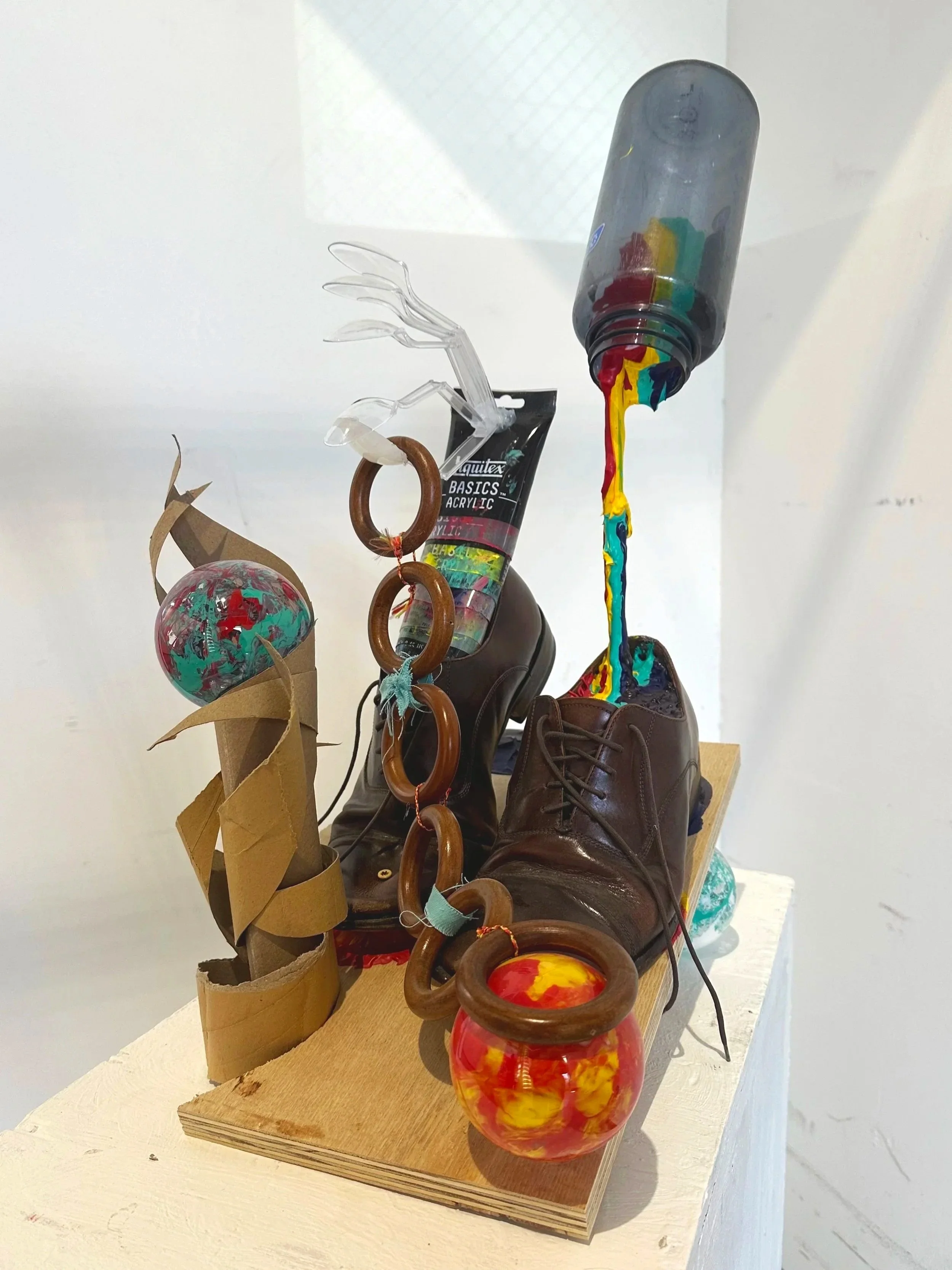 23in x 18in x 12in (wood, shoe, cardboard, bottle, plastic ornaments, paint tubes, spoons, curtain rings, string, acrylic paint)