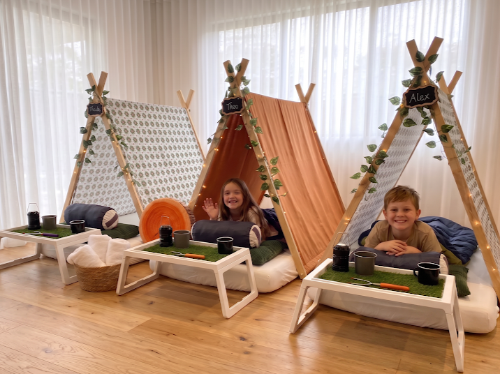 Indoor camping themed teepee party with cosy bedding and camping decor.