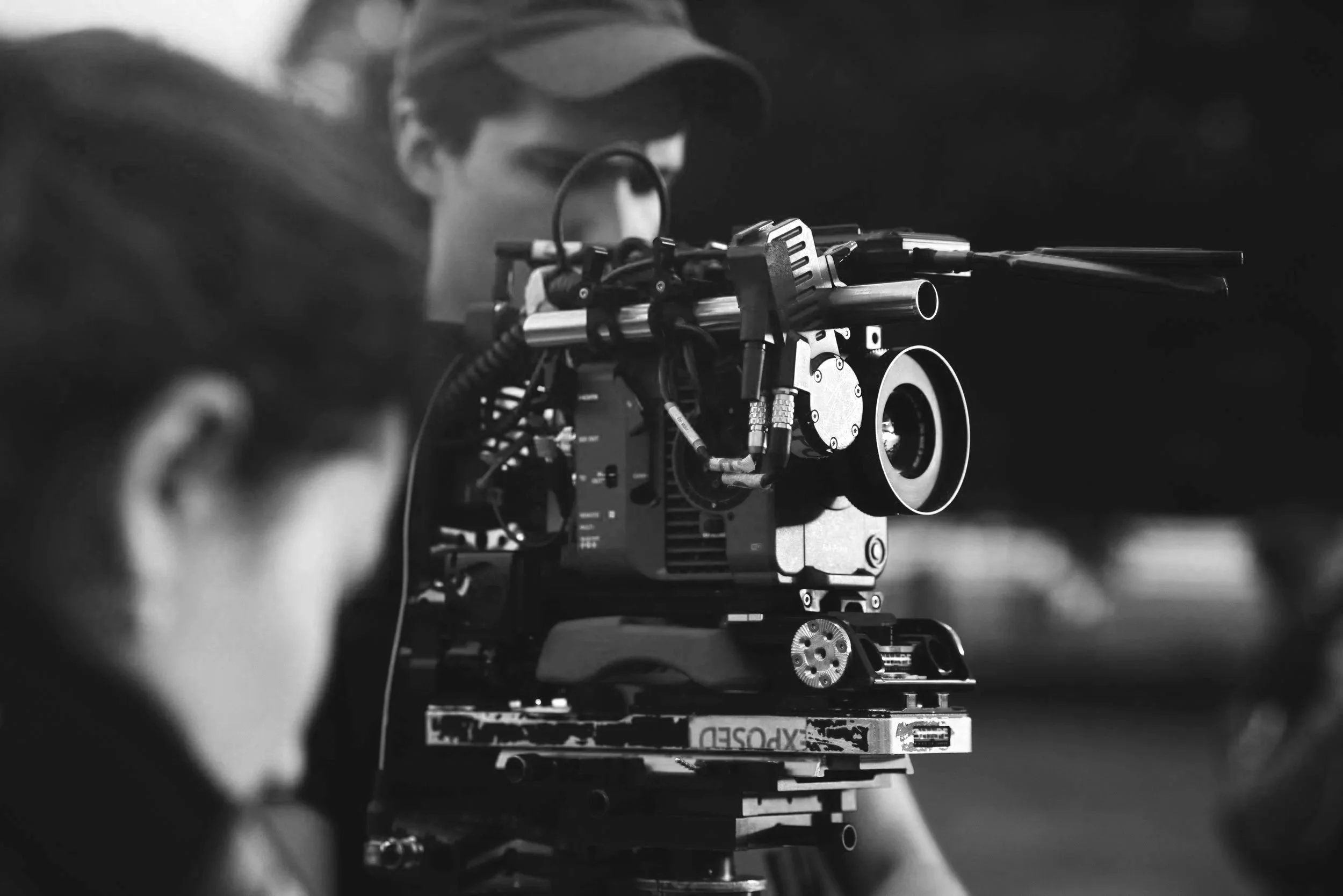 Black and white photo of a Kronos Creative Agency cinematographer and 1st AC building a professional camera setup for a music video