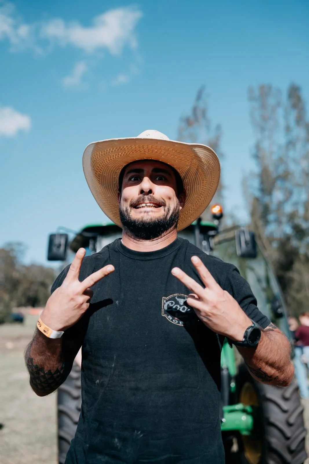 Farm Strong competitor in a straw cowboy hat grinning at The Farm Jam strongman day, Tocal College