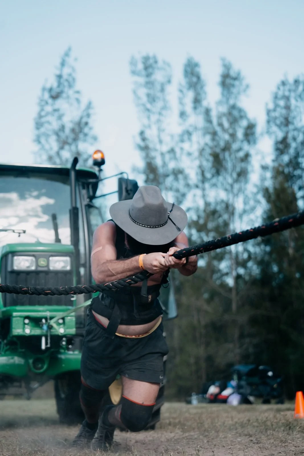 Farm Strong athlete in an Akubra hauling the rope on the tractor pull at The Farm Jam, Tocal College