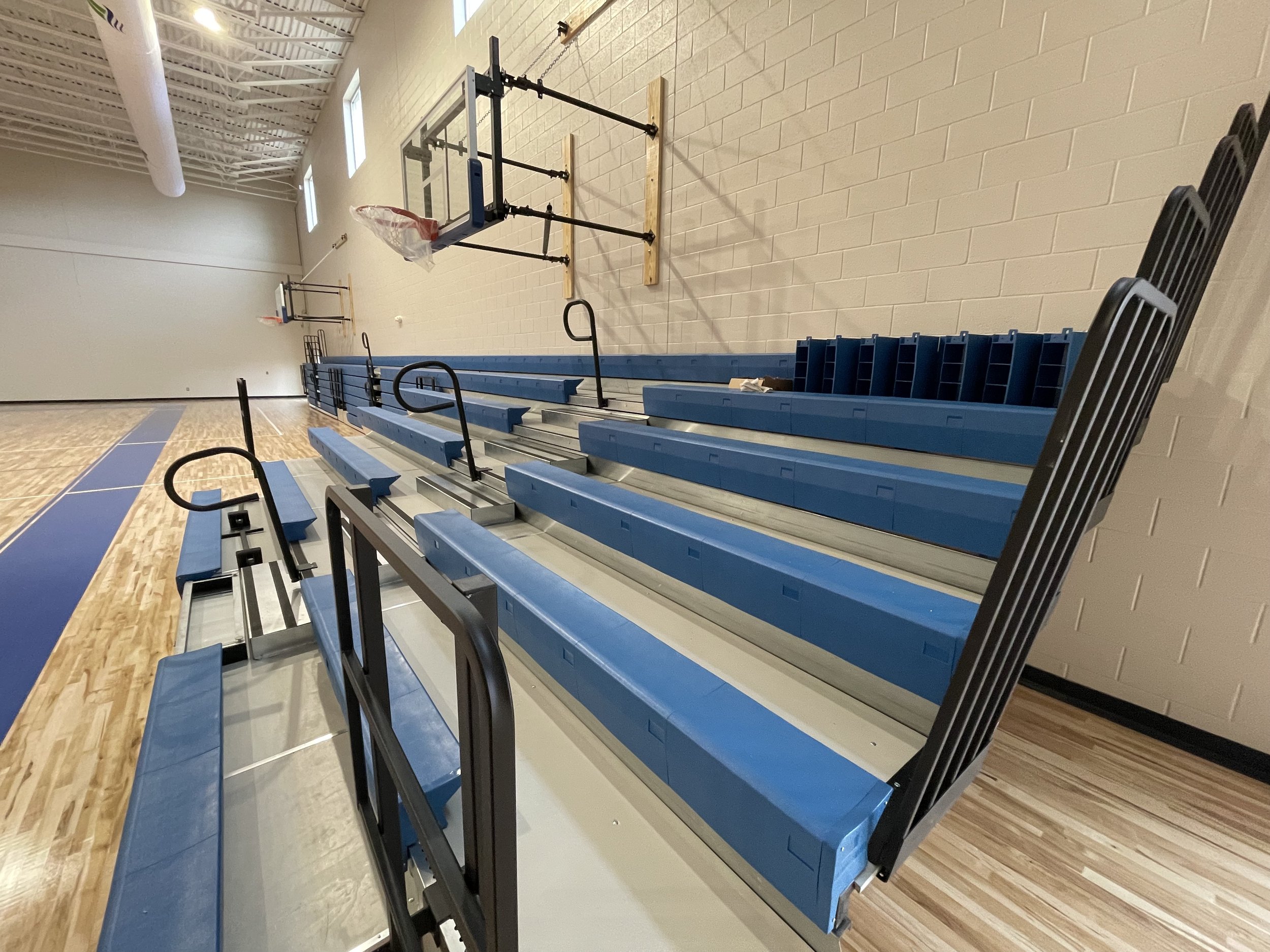Indoor gymnasium with bleachers and basketball hoops