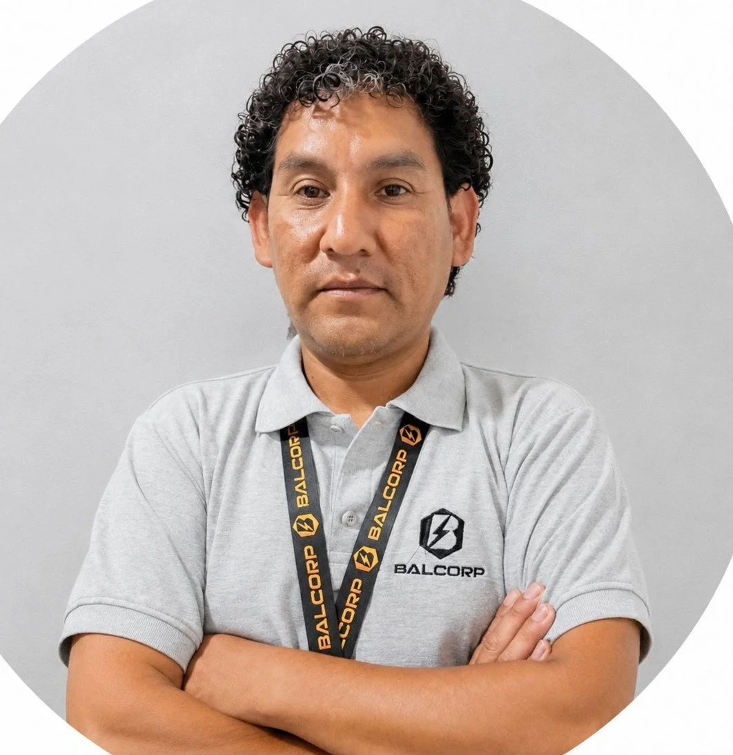 Retrato de un hombre con camisa gris y gafete con el logo y nombre "Balcrop" en el fondo gris.