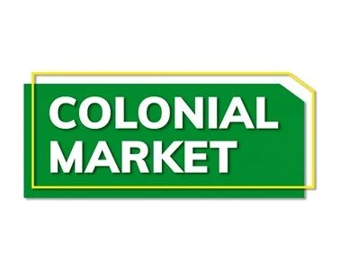 Cartel con fondo verde y borde amarillo que dice 'Colonial Market' en letras blancas.