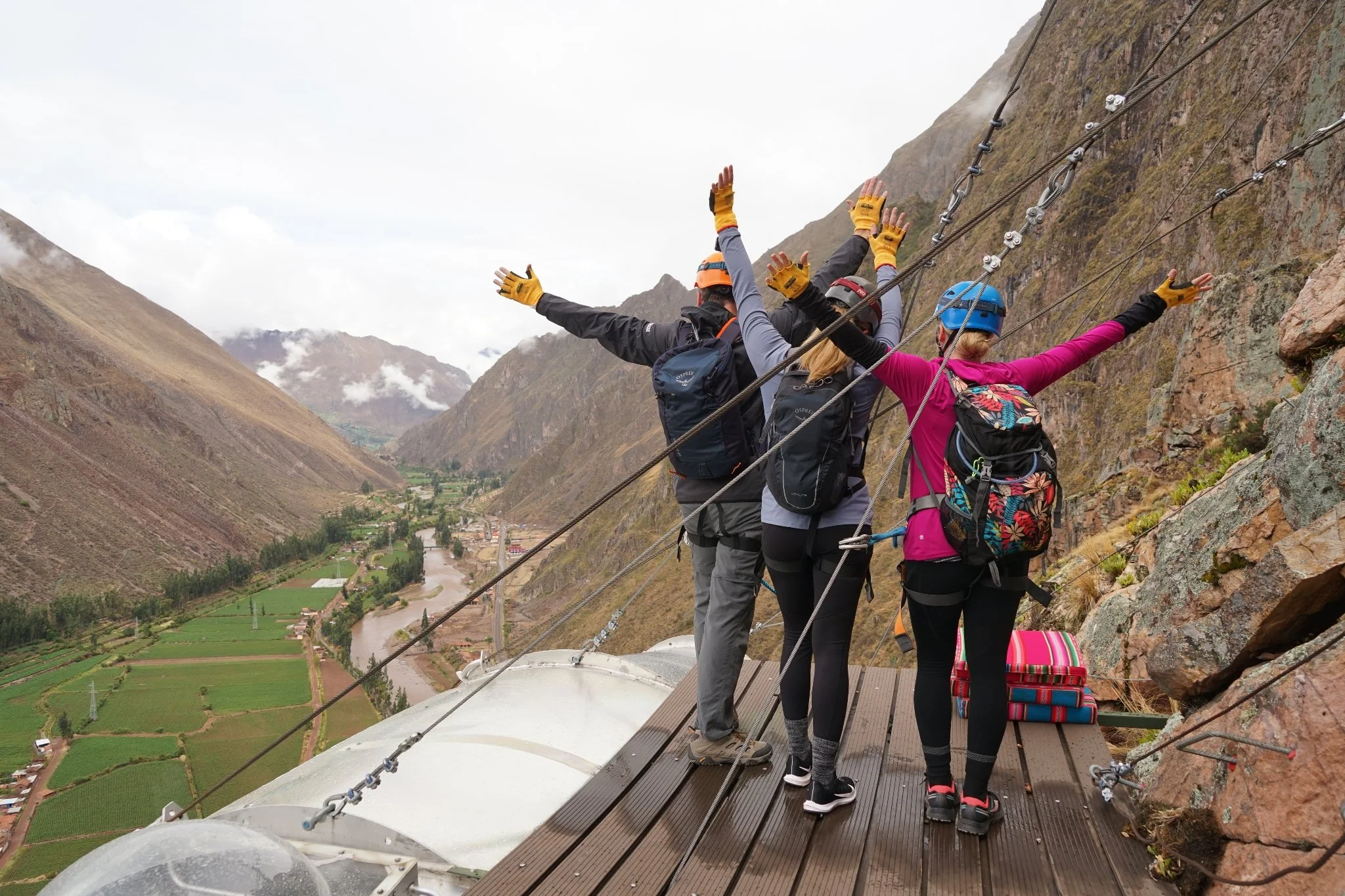 Adventure travelers standing on the platform of the Skylodge Adventure Suites overlooking Peru’s Sacred Valley, highlighting signature South American expeditions and custom itinerary planning by The Unpunctual.