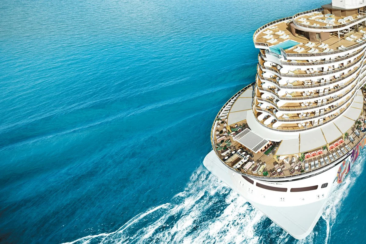 Aerial view of a modern Norwegian Cruise Line ship sailing through bright blue ocean waters, representing signature freestyle cruise vacations and personalized sea travel coordination.