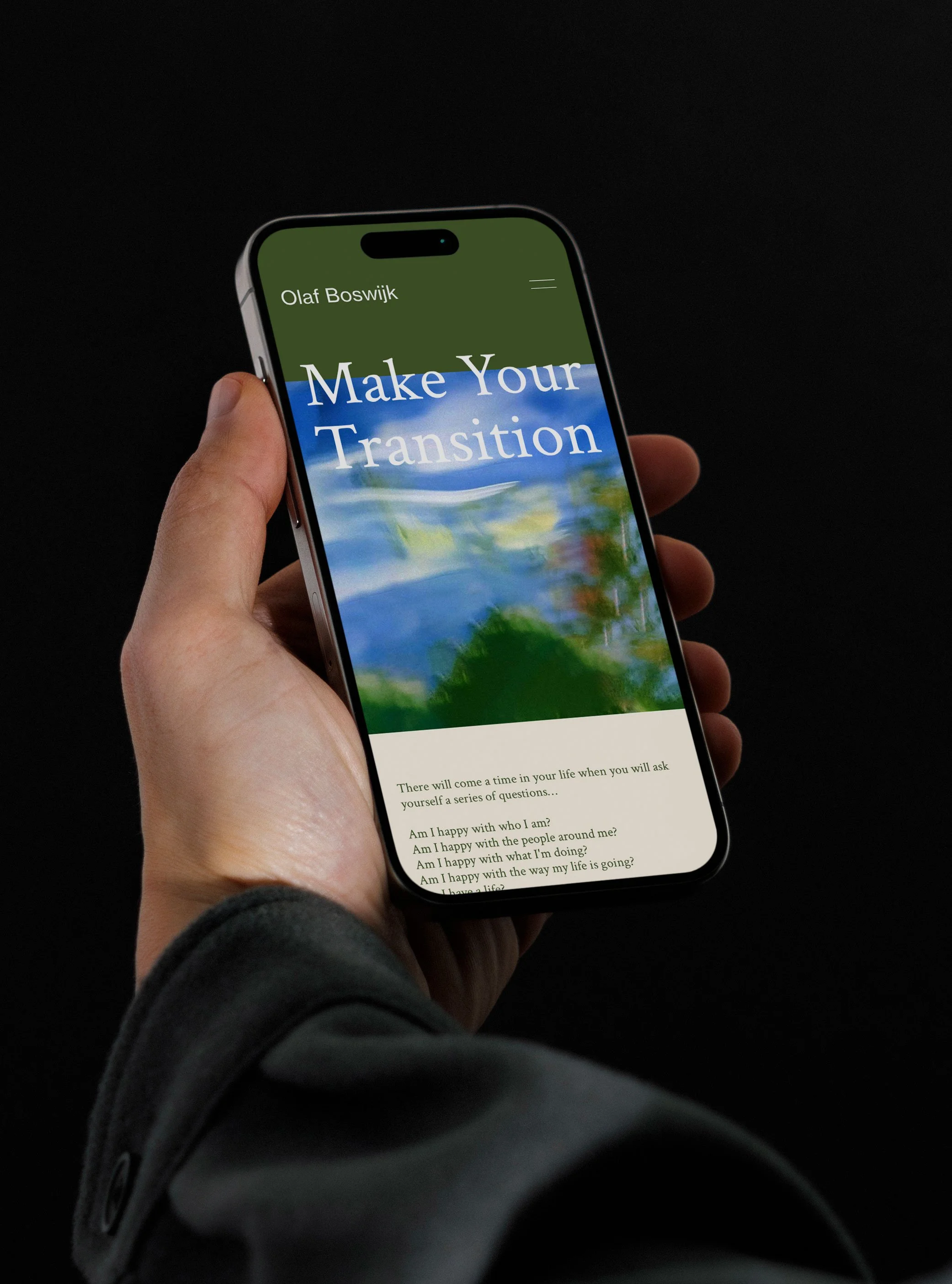 Hand holding a smartphone displaying the website of cultural entrepeneur Olaf Boswijk, with the title 'Make Your Transition' and a scenic background image.