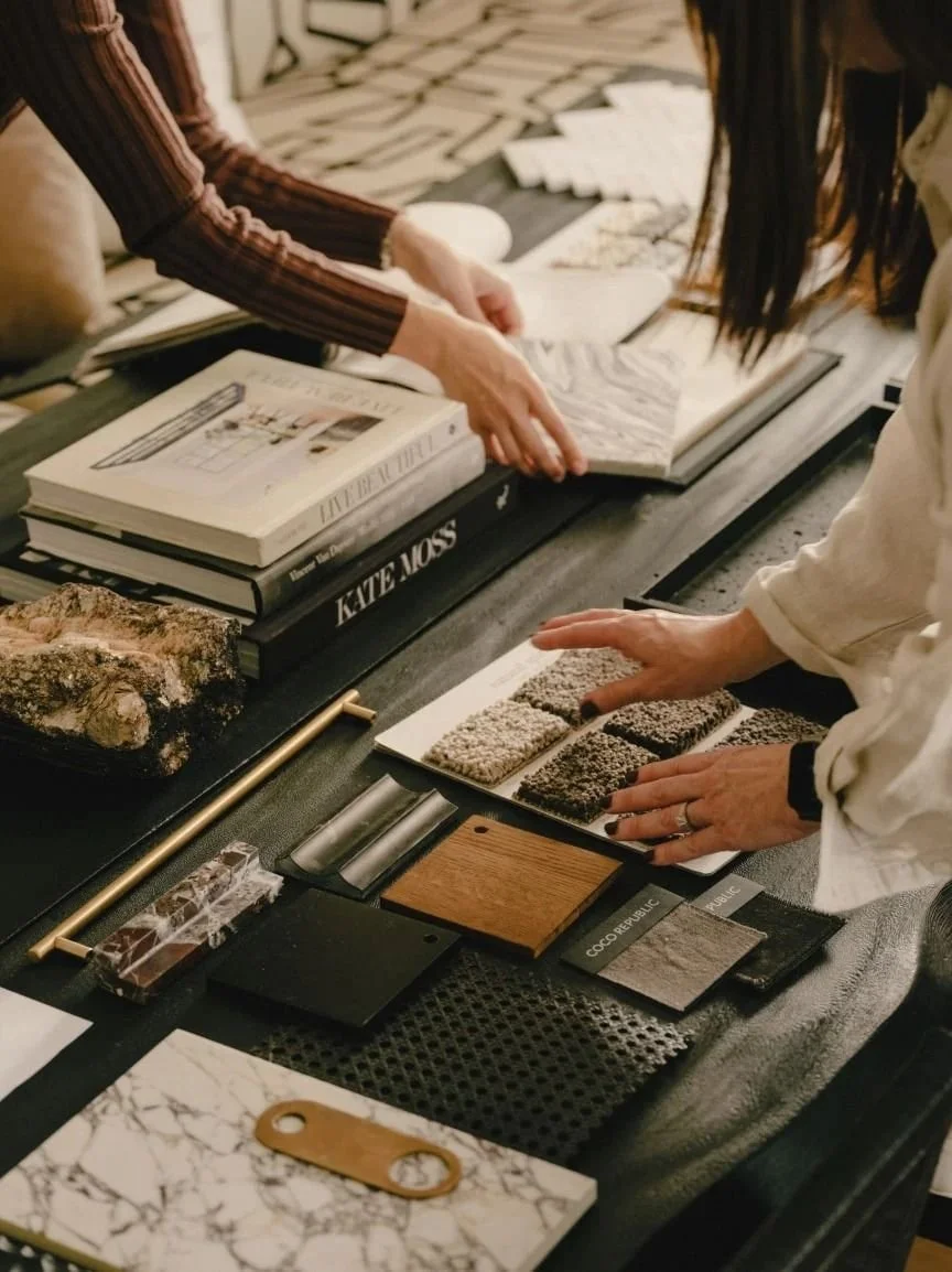 „Belsőépítész természetes kő és felületmintákat válogat egy enteriőr tervezési folyamat során. A képen a tudatos anyagválasztás és a részletekre épülő döntések jelennek meg, amelyek meghatározzák egy igényes otthon minőségét és költségét.