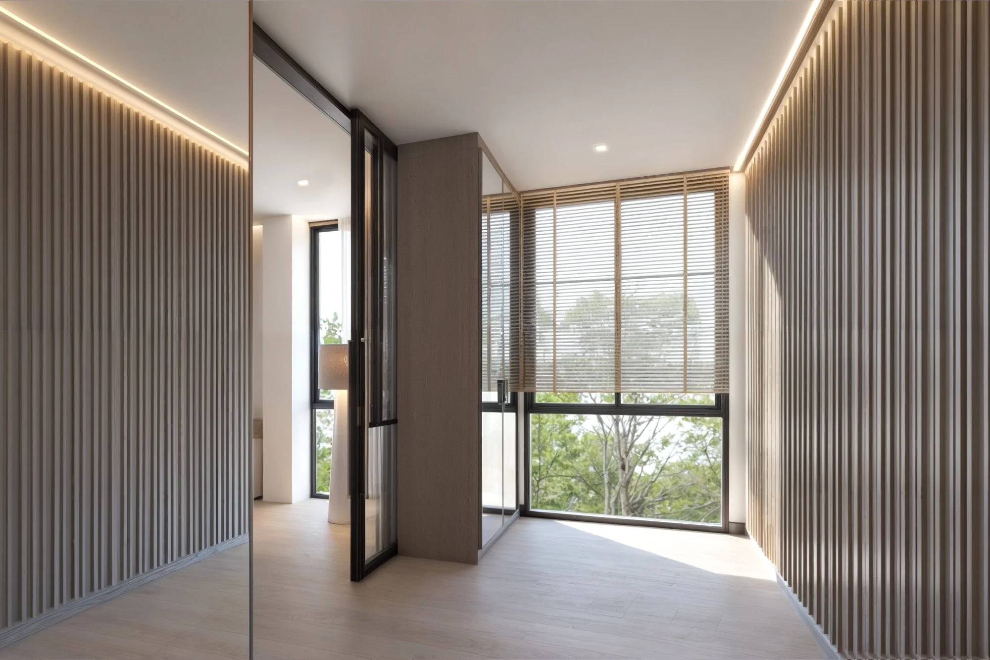 Interior hallway opening to a balcony with vertical architectural fins for privacy and ventilation.